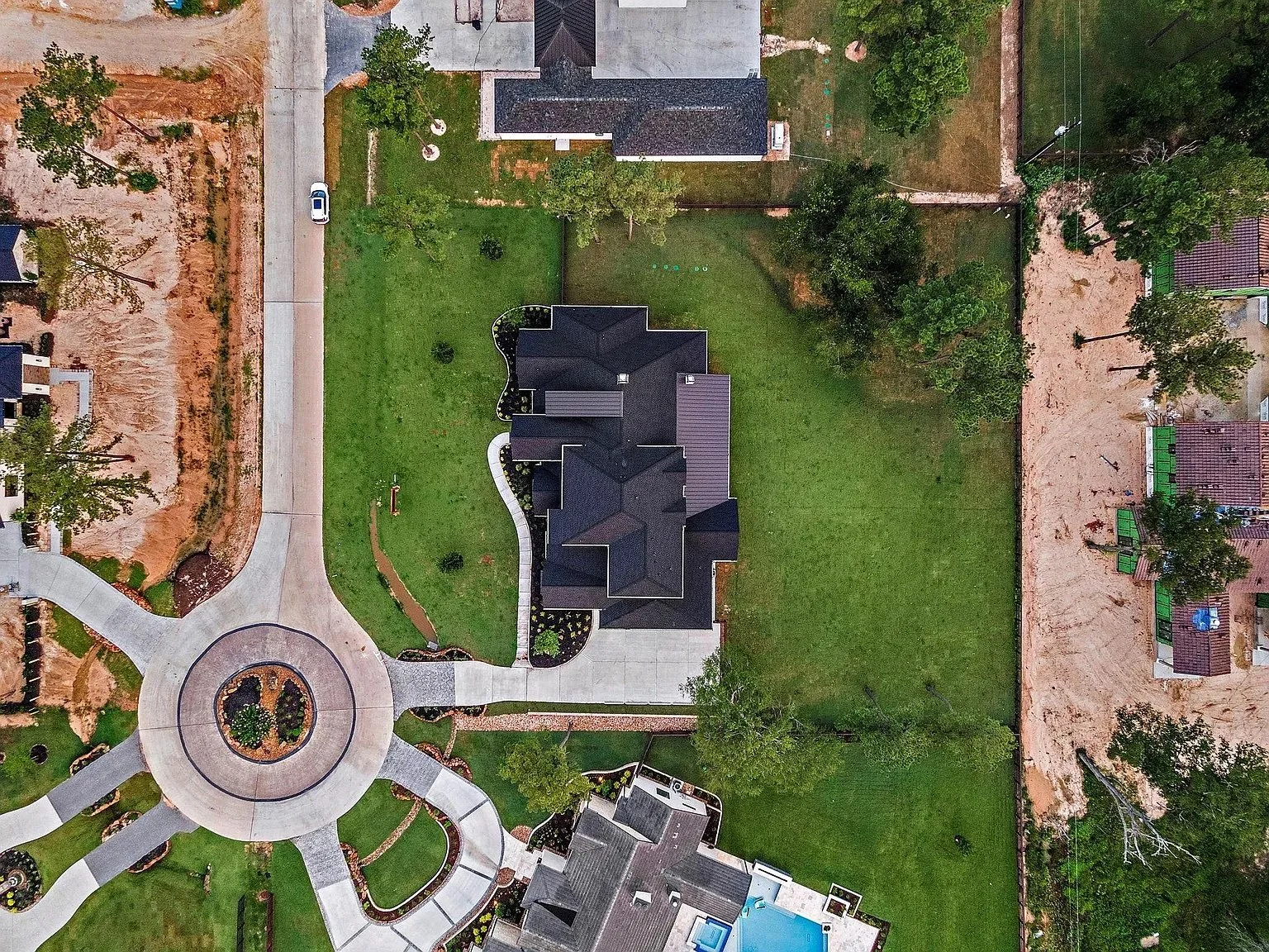 Top-down view of a suburban neighborhood featuring new construction and a central roundabout