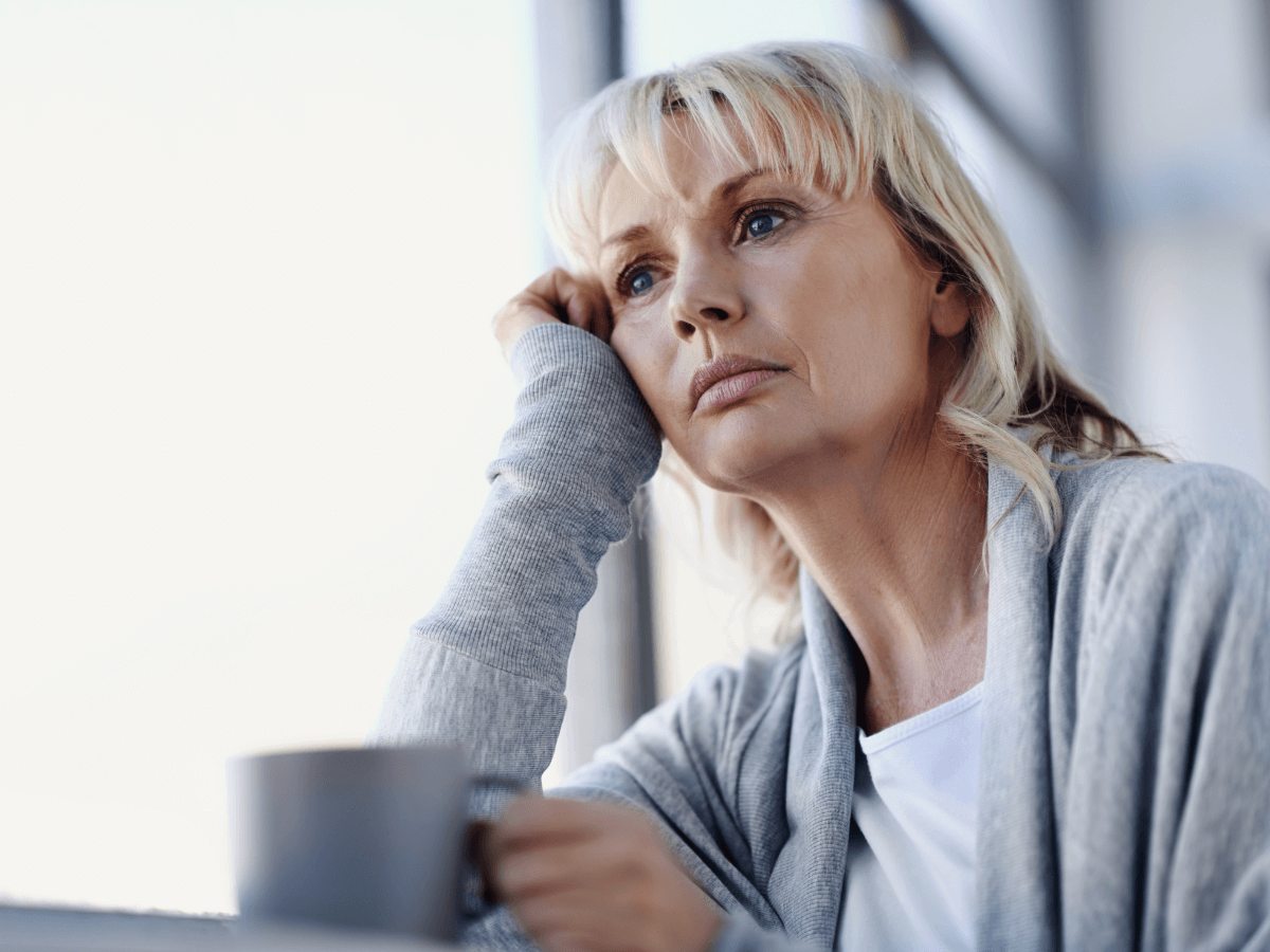 Woman looks pensive thinking how Anosognosia in Bipolar Disorder has affected her life.