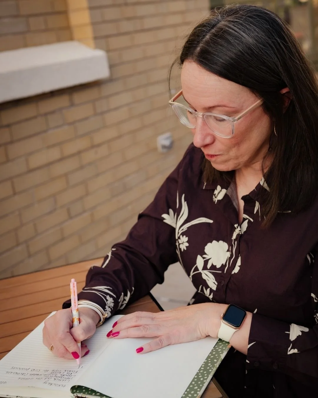 Emily Mendez writing notes in a notebook, mental health writer and founder of Thriving With Bipolar