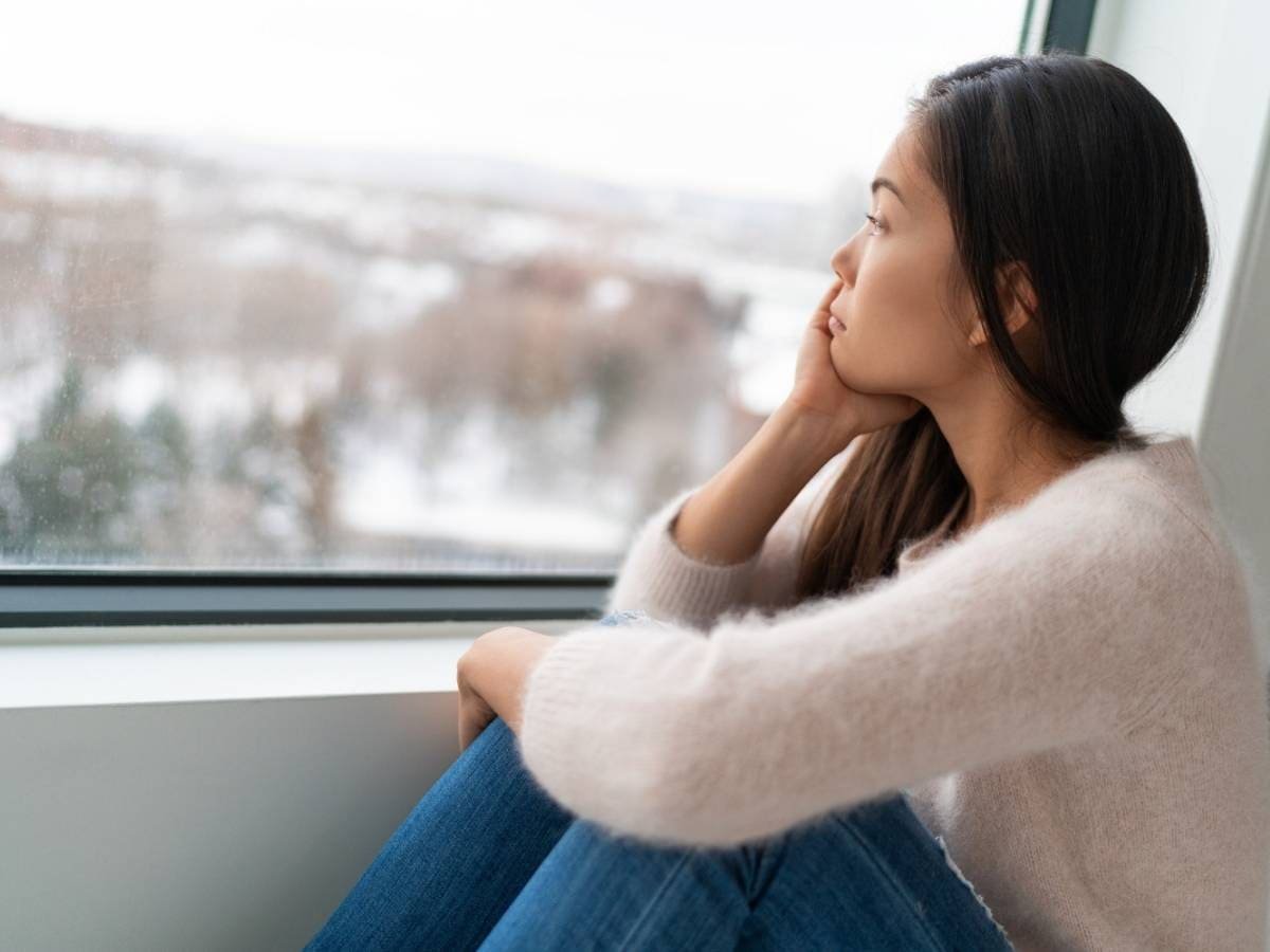 Woman looking out window seasonal bipolar depression