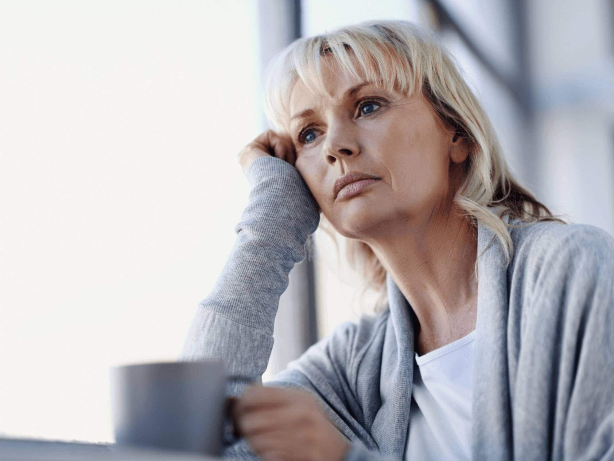 Woman looks pensive thinking how Anosognosia in Bipolar Disorder has affected her life.