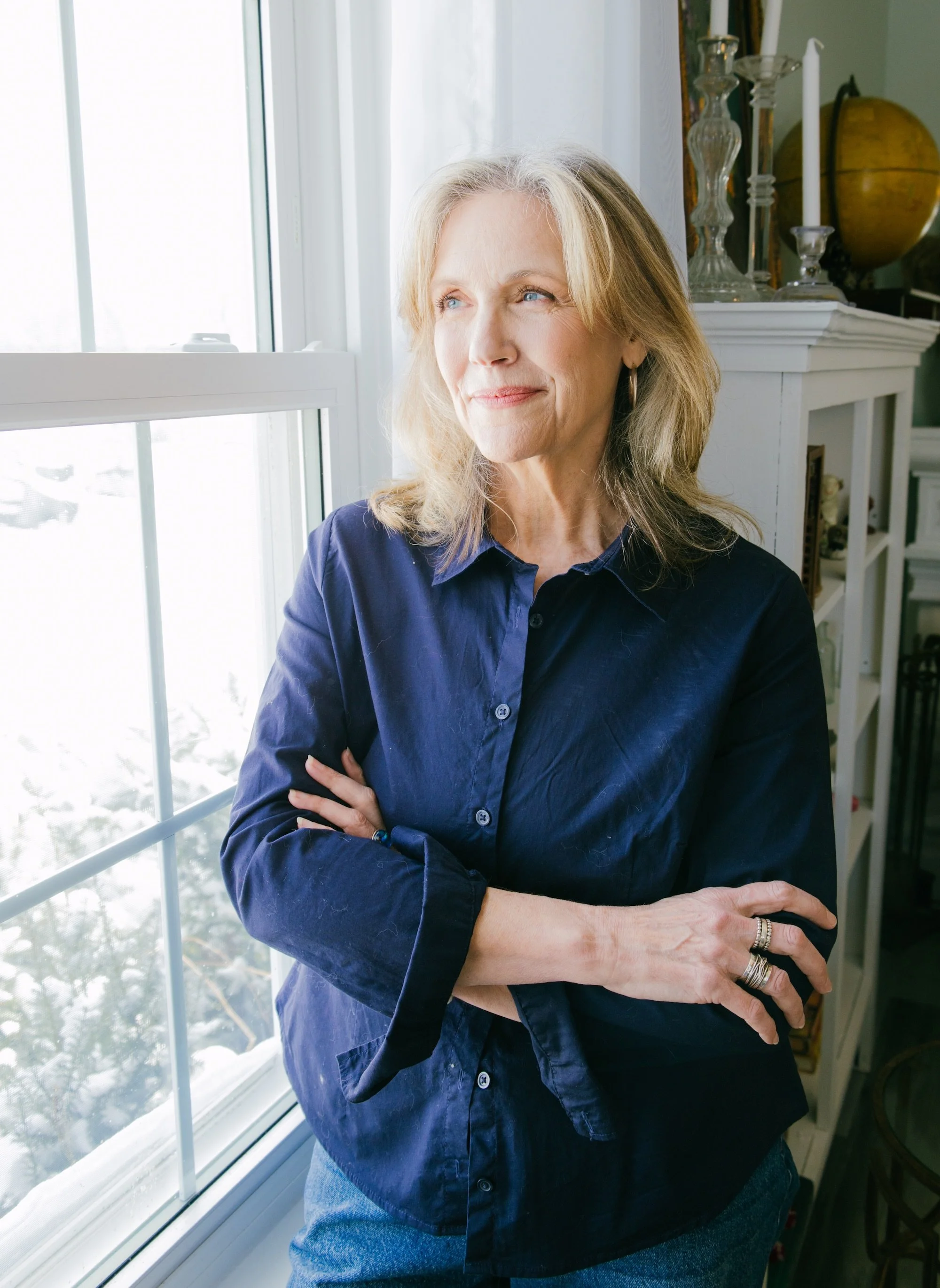Heather Masters by a window, reflecting on thirty years of intuitive and animal communication work