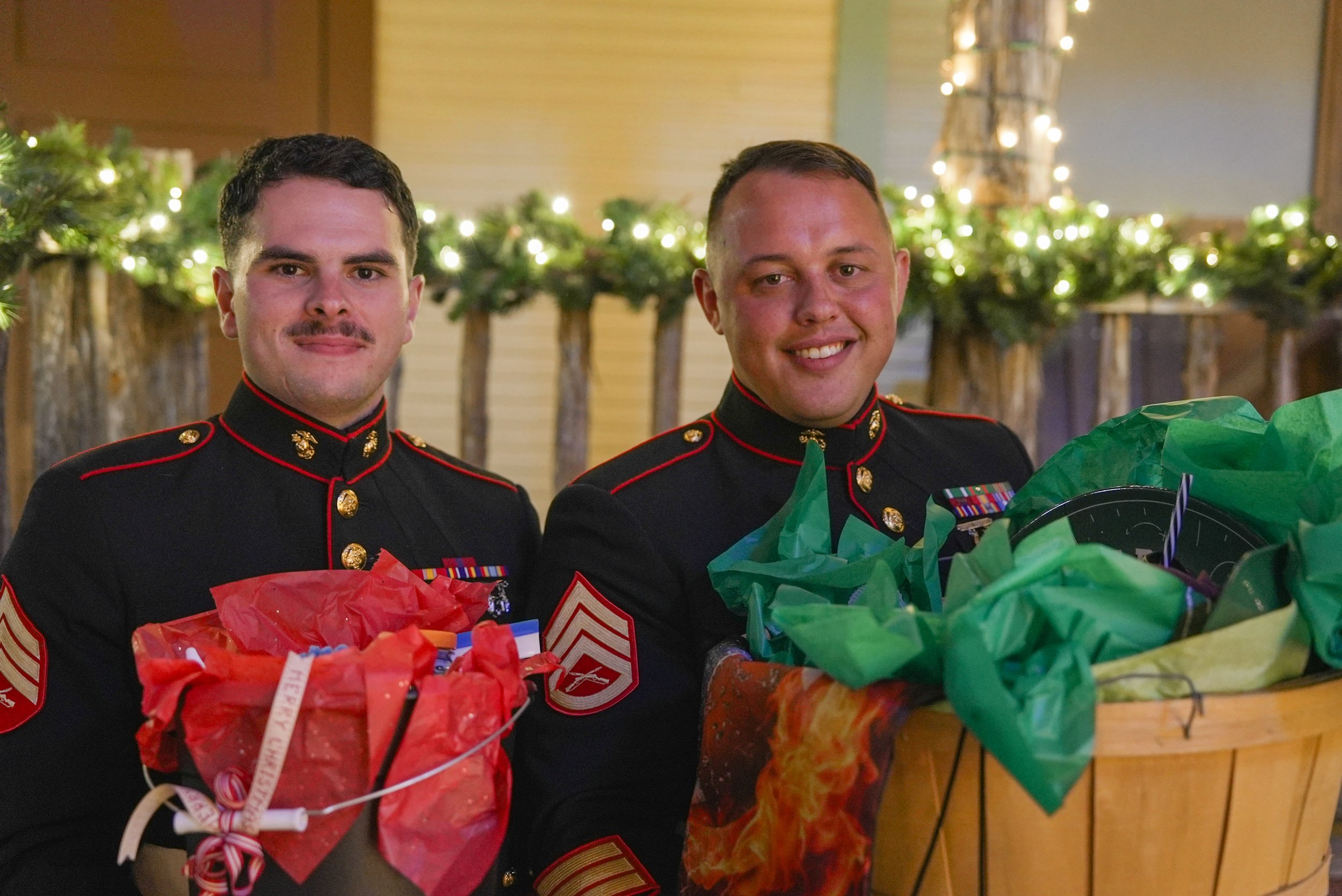 Two uniformed officers holding gift baskets with festive decorations.