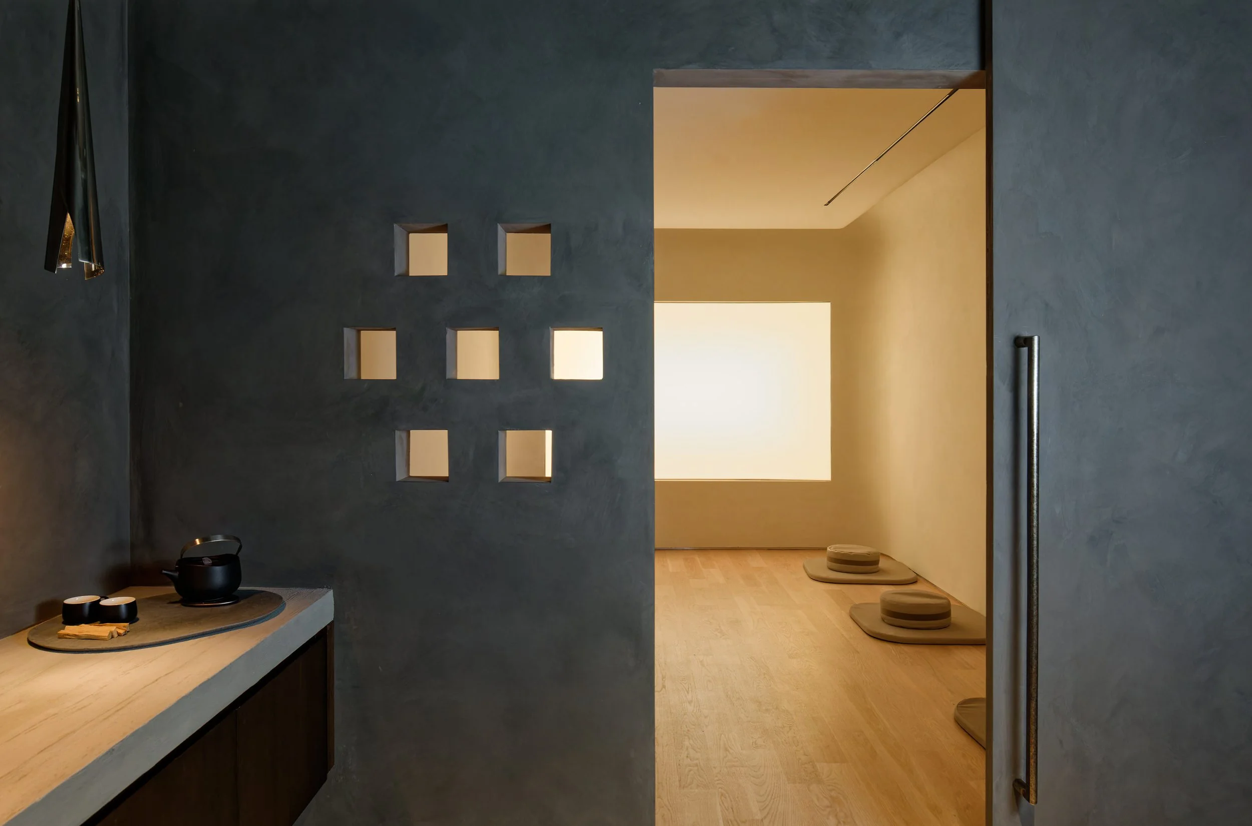 Charcoal meditation room entry with geometric cutout wall, cocoon-like transitional space, Renee Labbe Design Futures, Bell Design Group