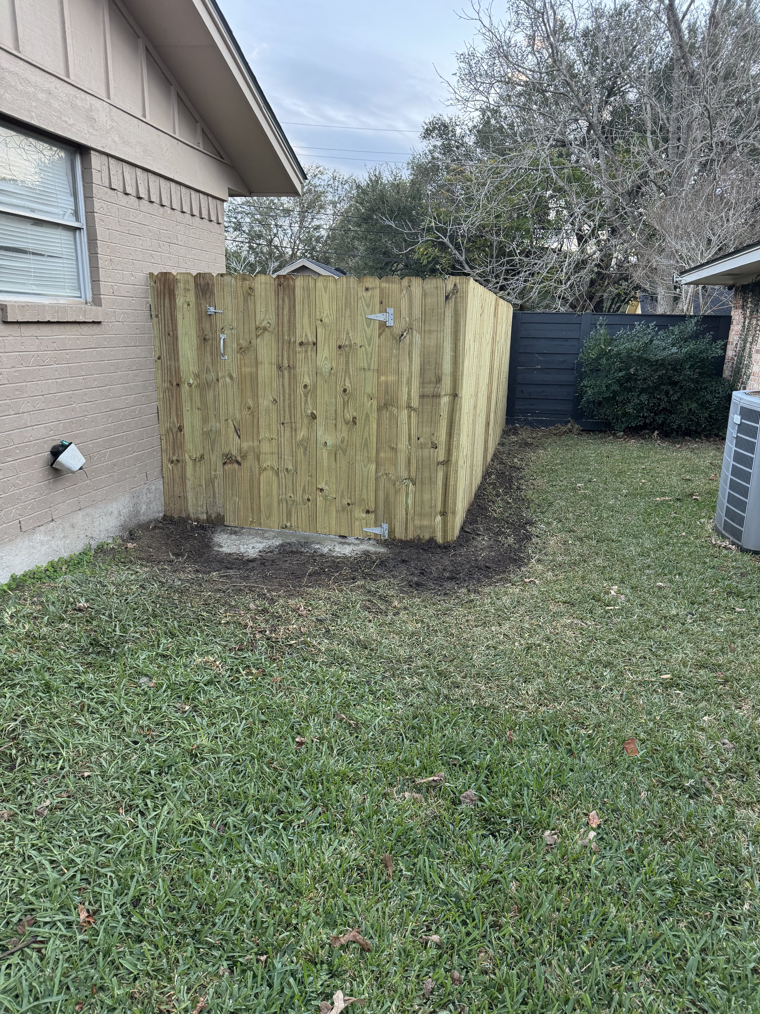 Wood privacy fence repaired and aligned along backyard property line.