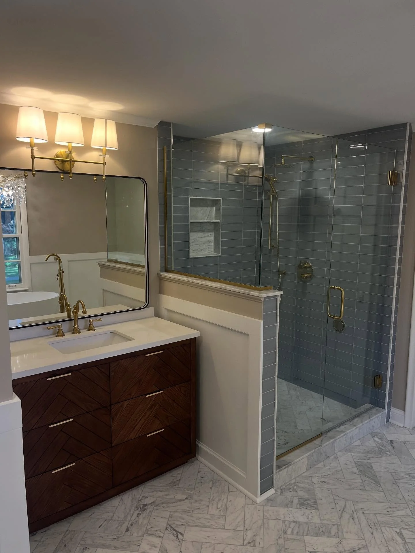 Beautiful herringbone pattern marble tile and luxurious soaking tub in this Grosse Pointe Farms bathroom! #grossepointe #grossepointefarms
