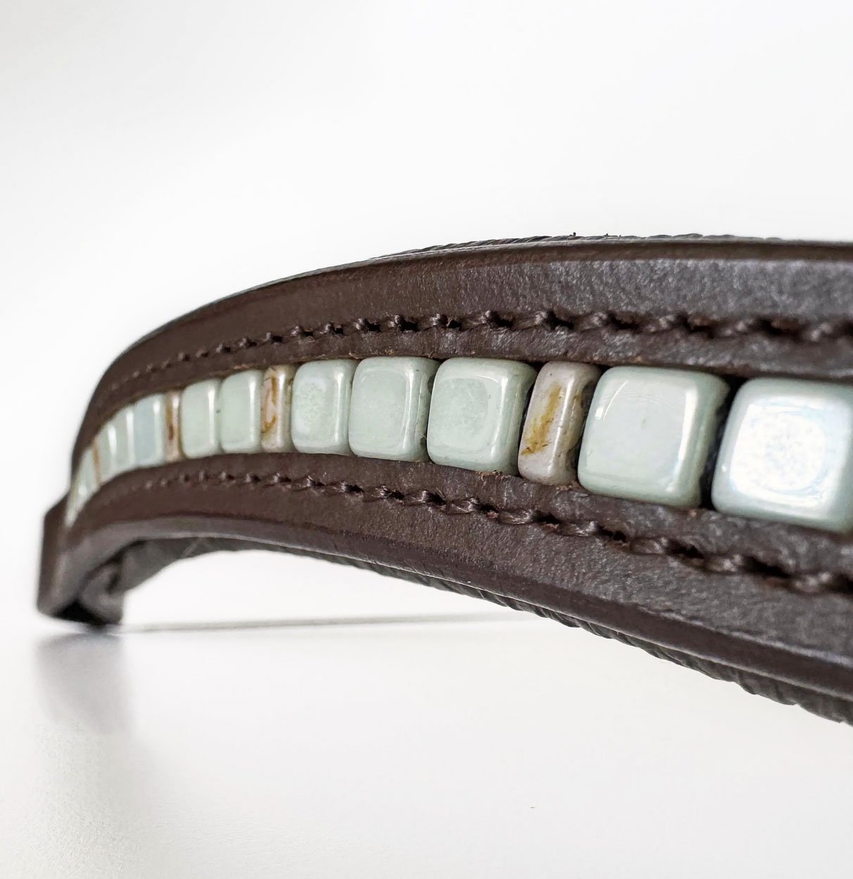 Close up of unique brown leather browband with sage green and tan beads