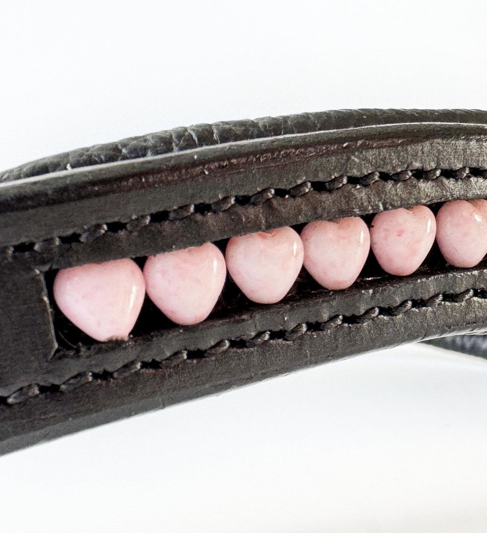 Close up of light pink heart beads in a black leather browband