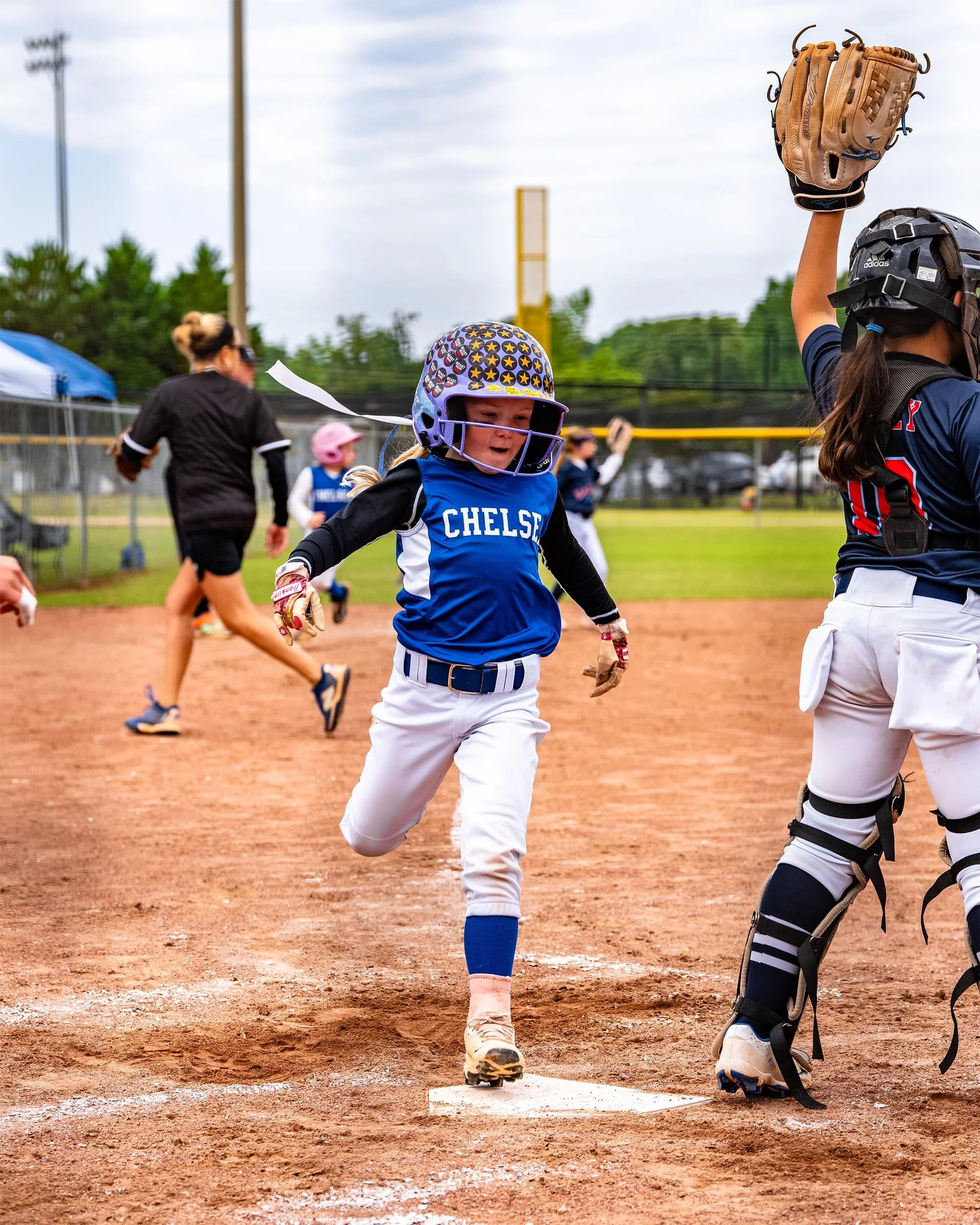 girl softball player crossing home plate