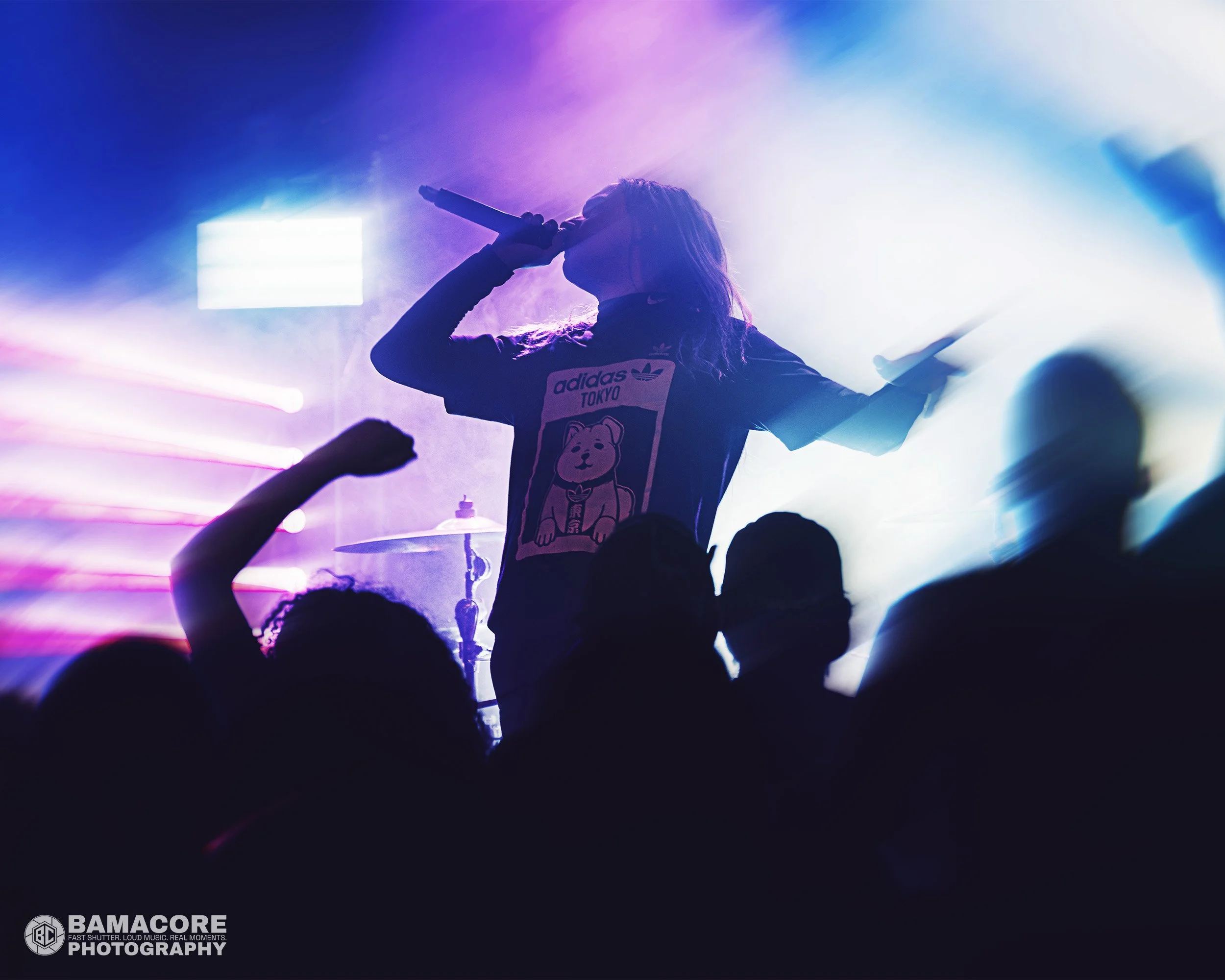 vocalist leaning back with microphone to his mouth.