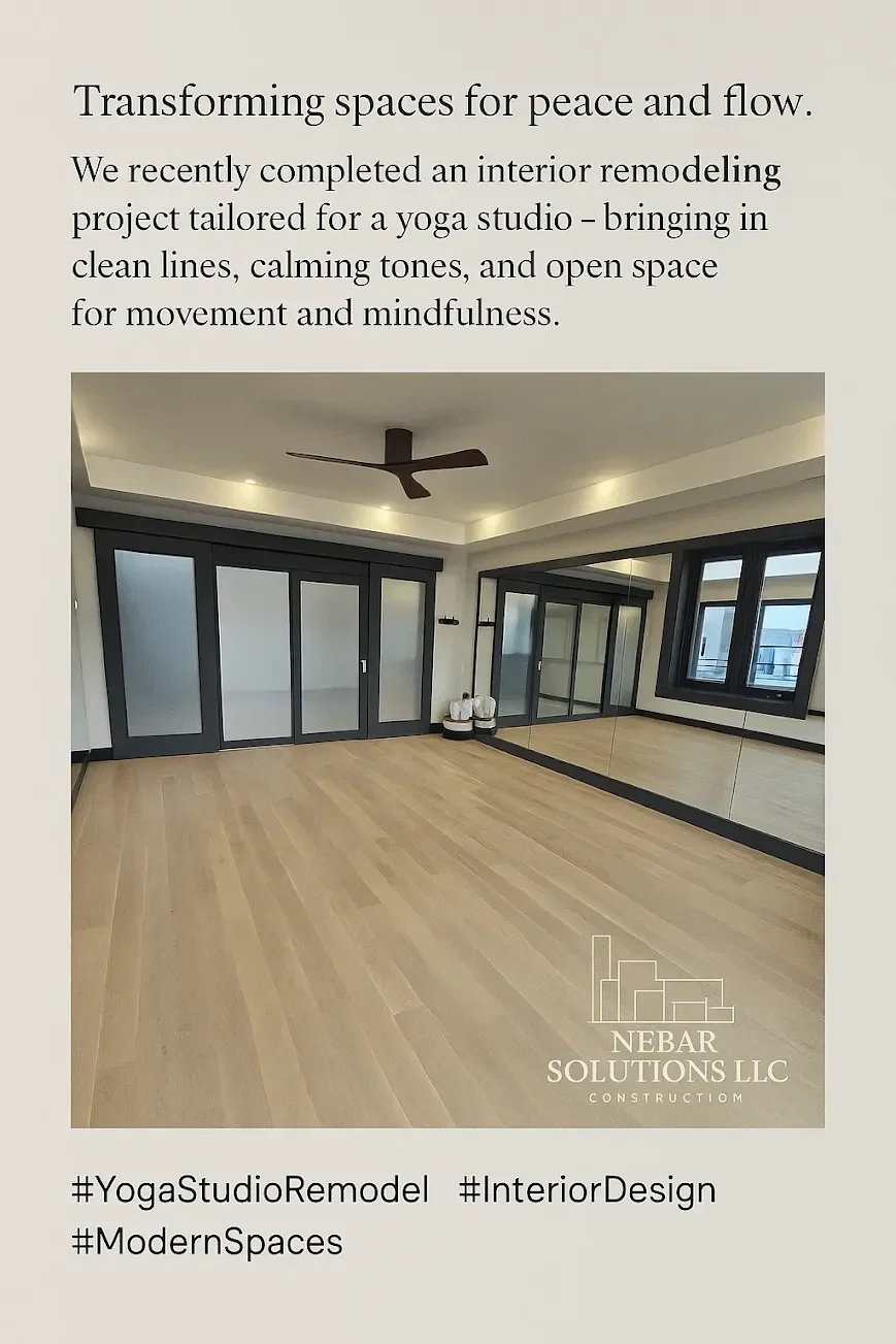 Empty modern yoga studio with light wood flooring, black framed glass doors, large window with black frame, ceiling fan, and mirror wall. Logo for Nebar Solutions LLC in the bottom right corner.