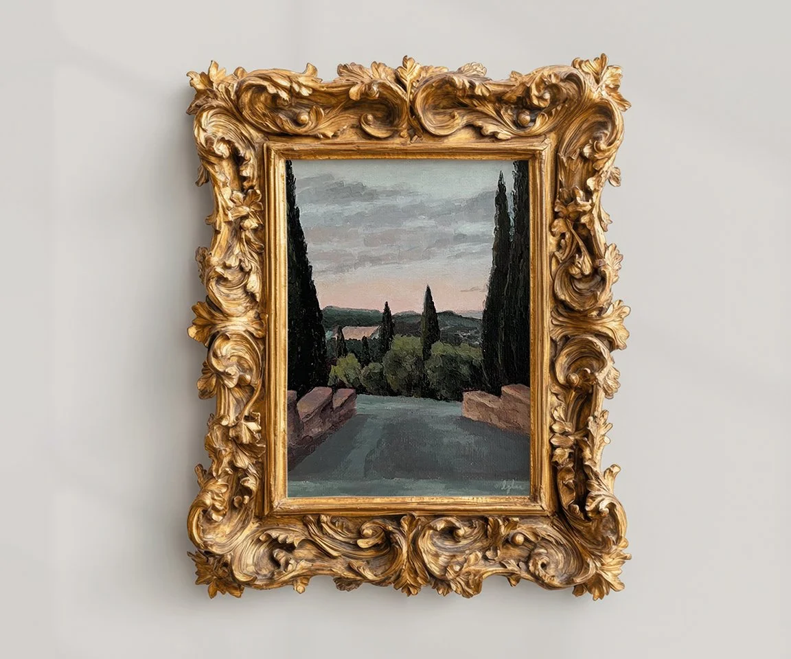 ornate gold frame framing painting of sunset over Tuscany