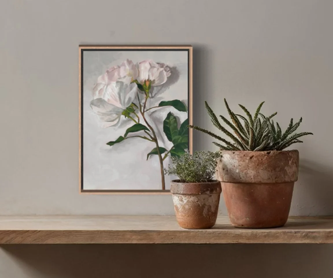 framed painting of roses on shelf with plants