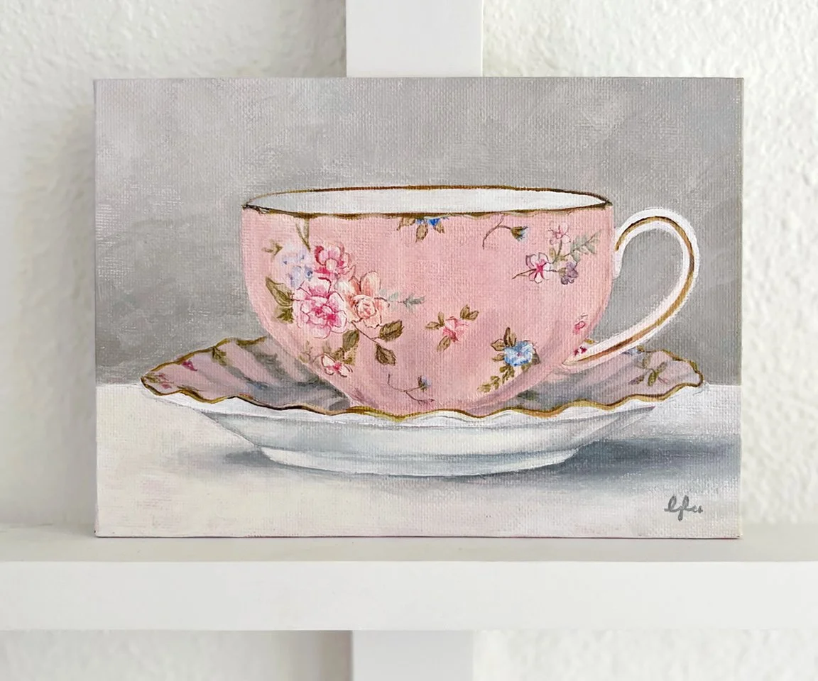 painting of pink teacup with floral print against white wall