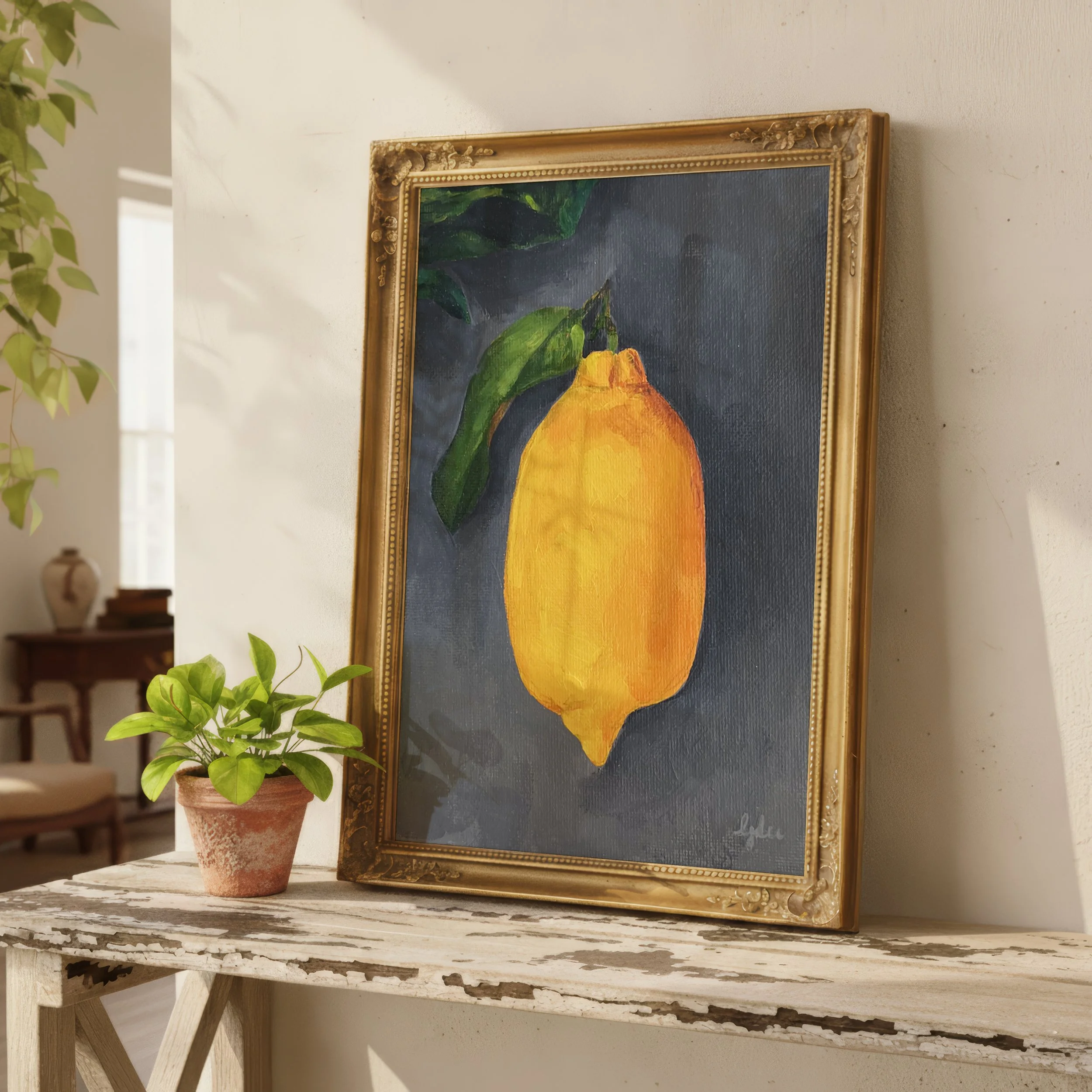 gold framed print of painting of lemon with leaf on gray background sitting on large shelf