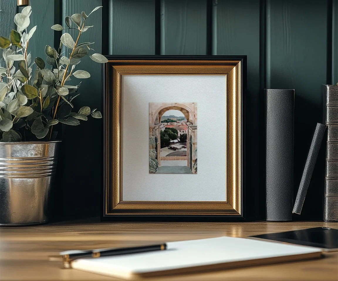 framed italian landscape painting print on desk