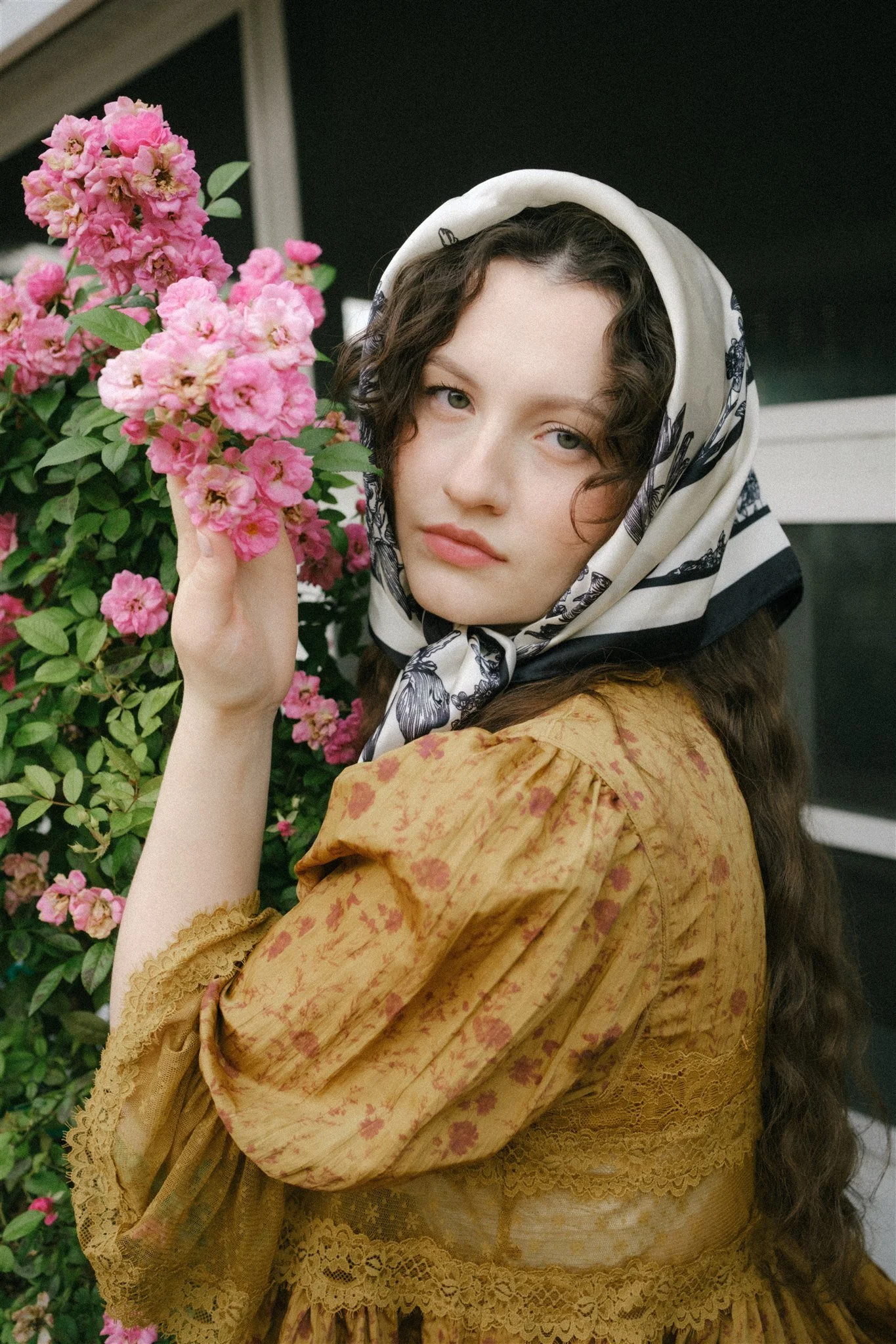  A woman outside holding pink flowers. 