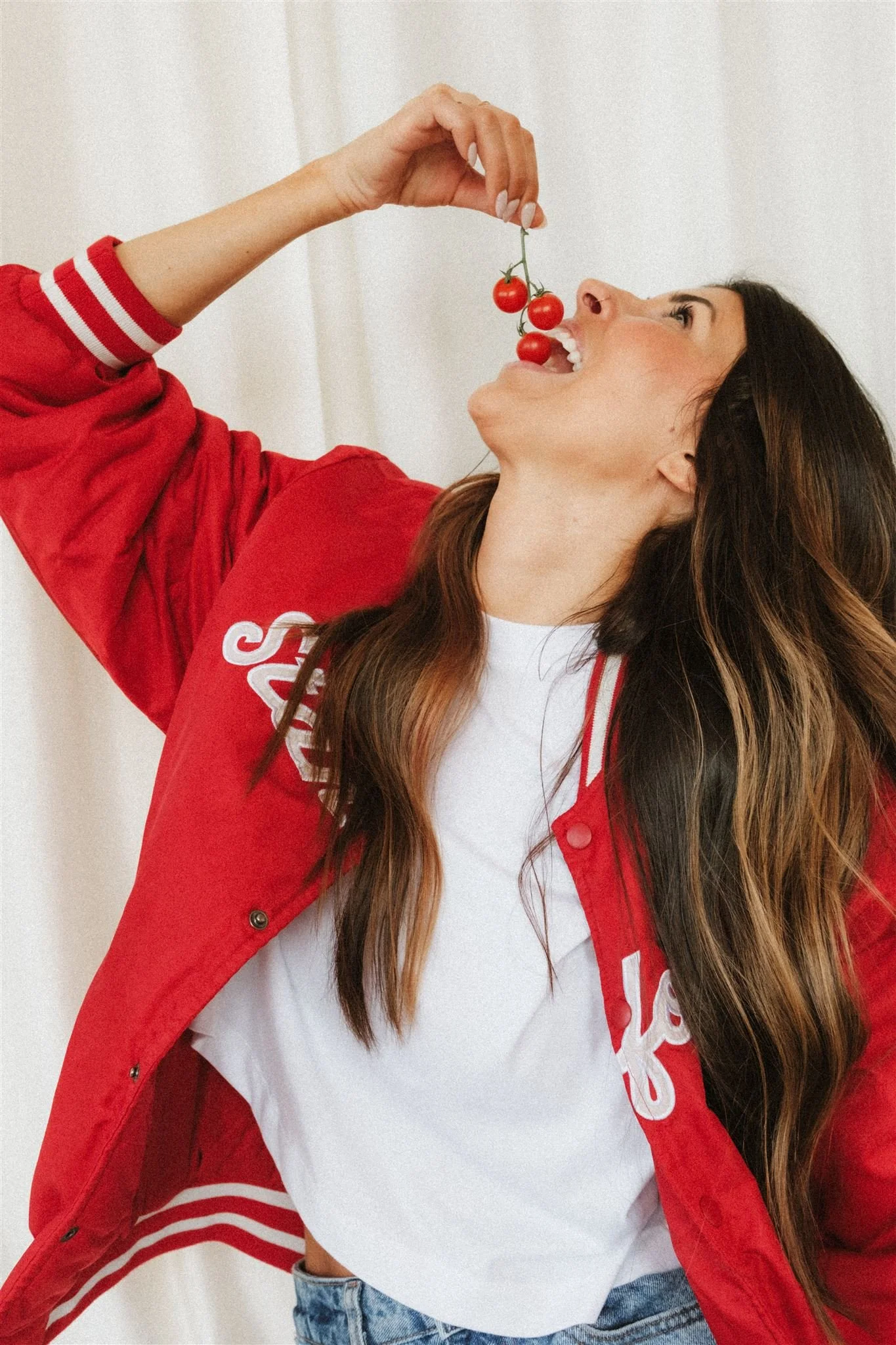  A woman eating tomatoes.  