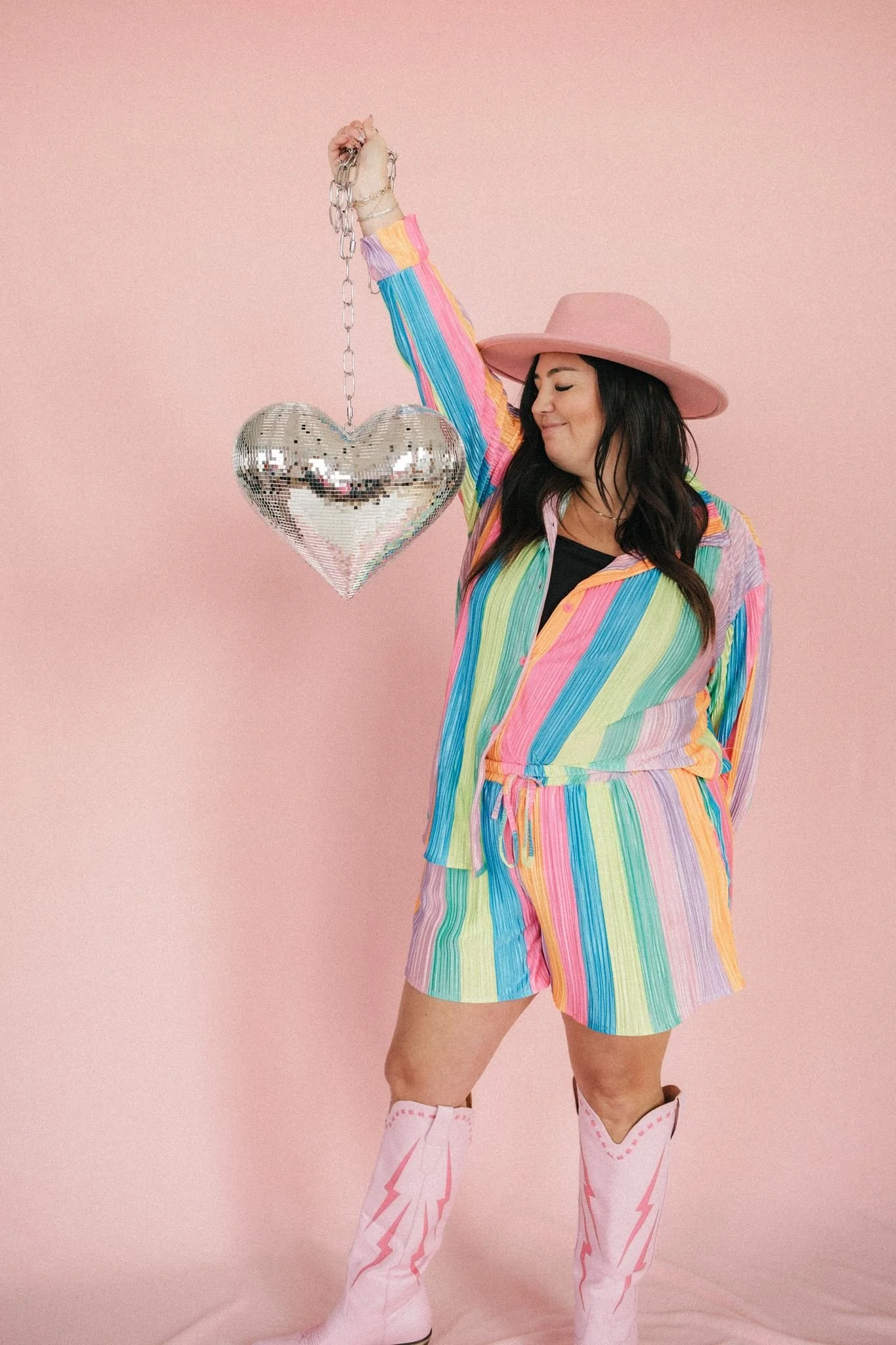  Brand photography of a woman holding a disco ball shaped as a heart. 