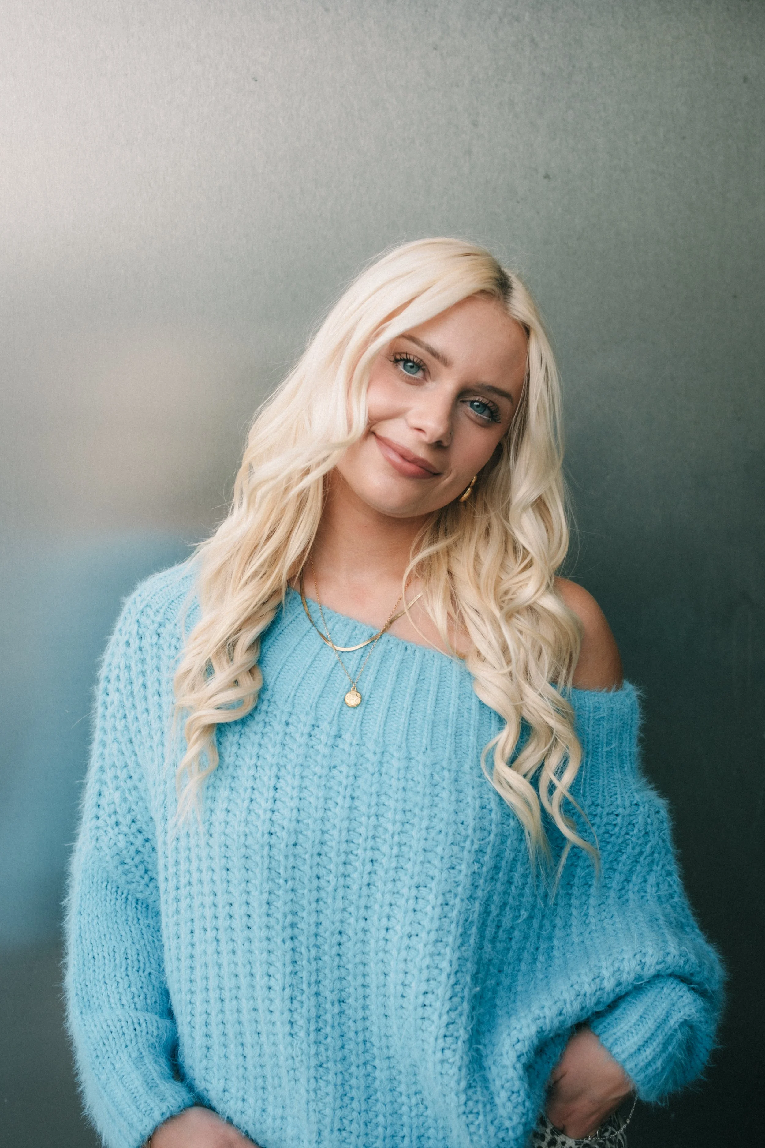  A woman wearing a sweater and jewelry.  