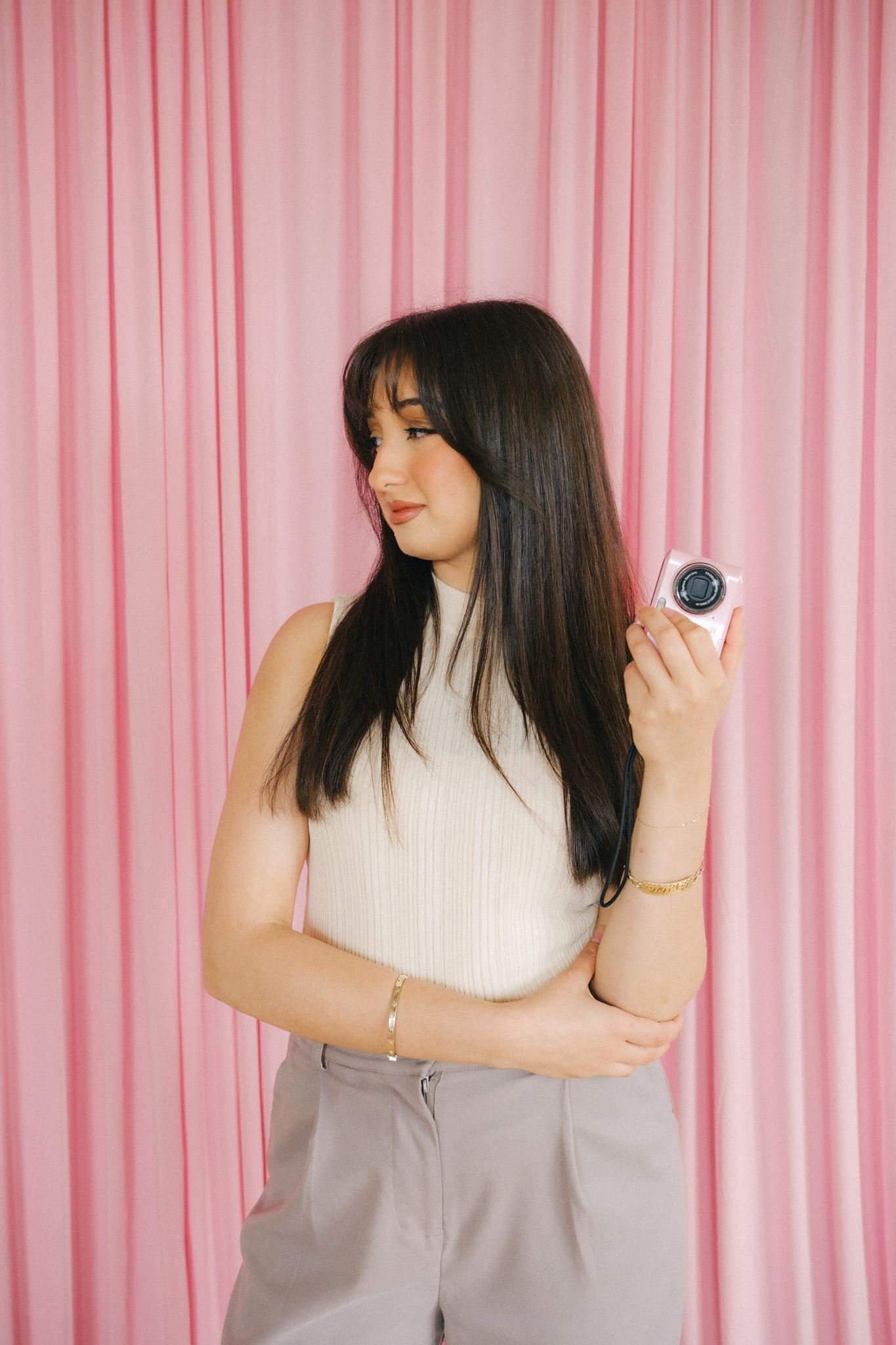  A business owner holding a pink camera as a photoshoot prop for brand photos in Kansas City. 