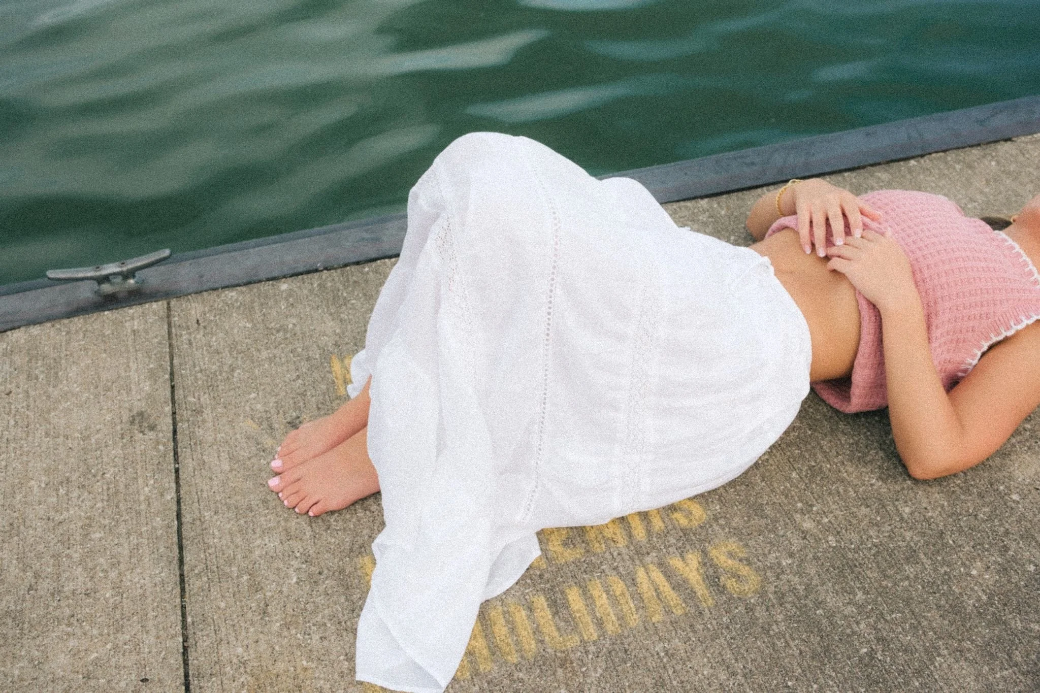 A business owner in a flowy white skirt by the water for unique brand photos in KC.