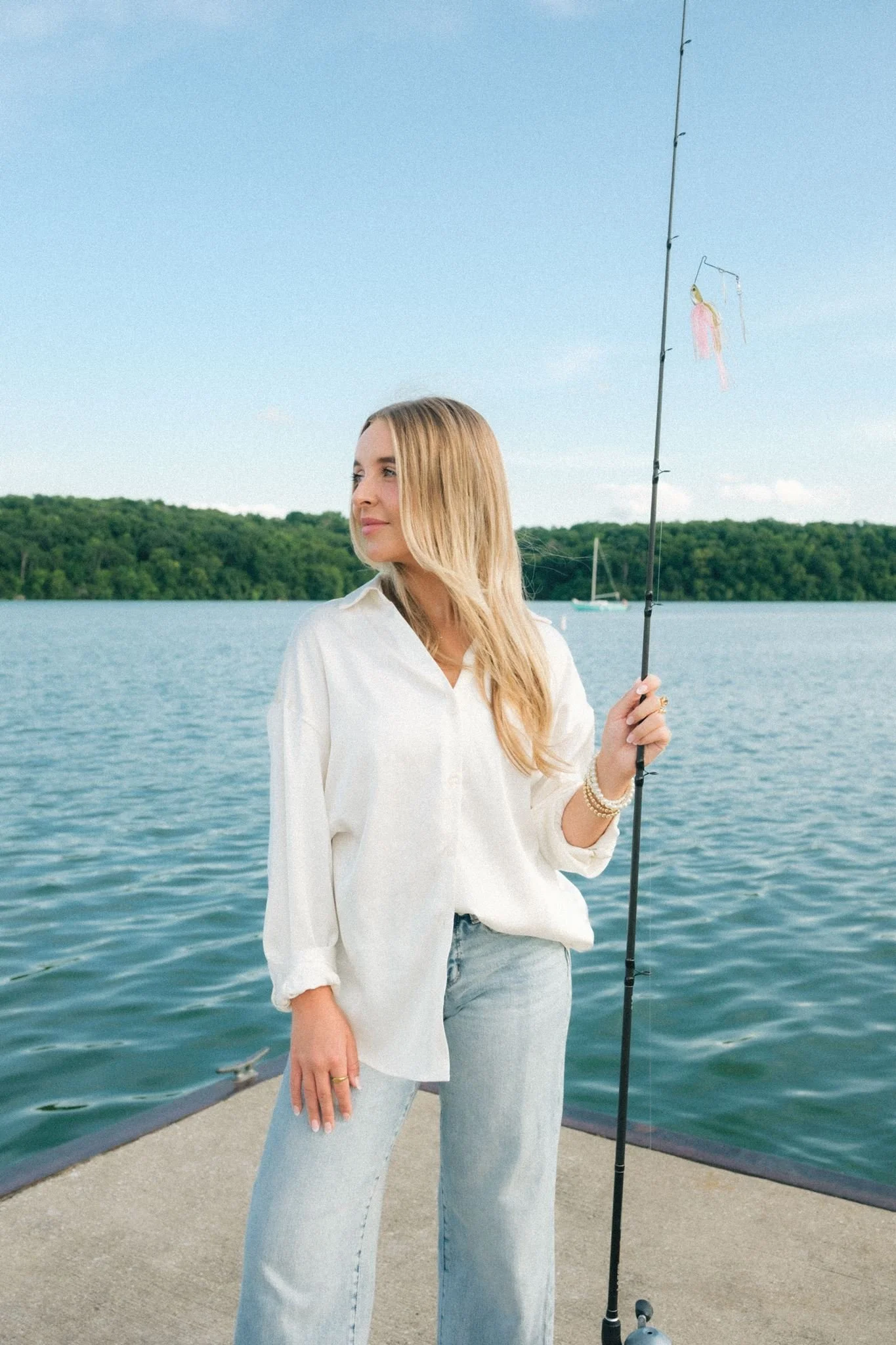  A woman holding a fishing pole as a prop for a brand photoshoot guide.  