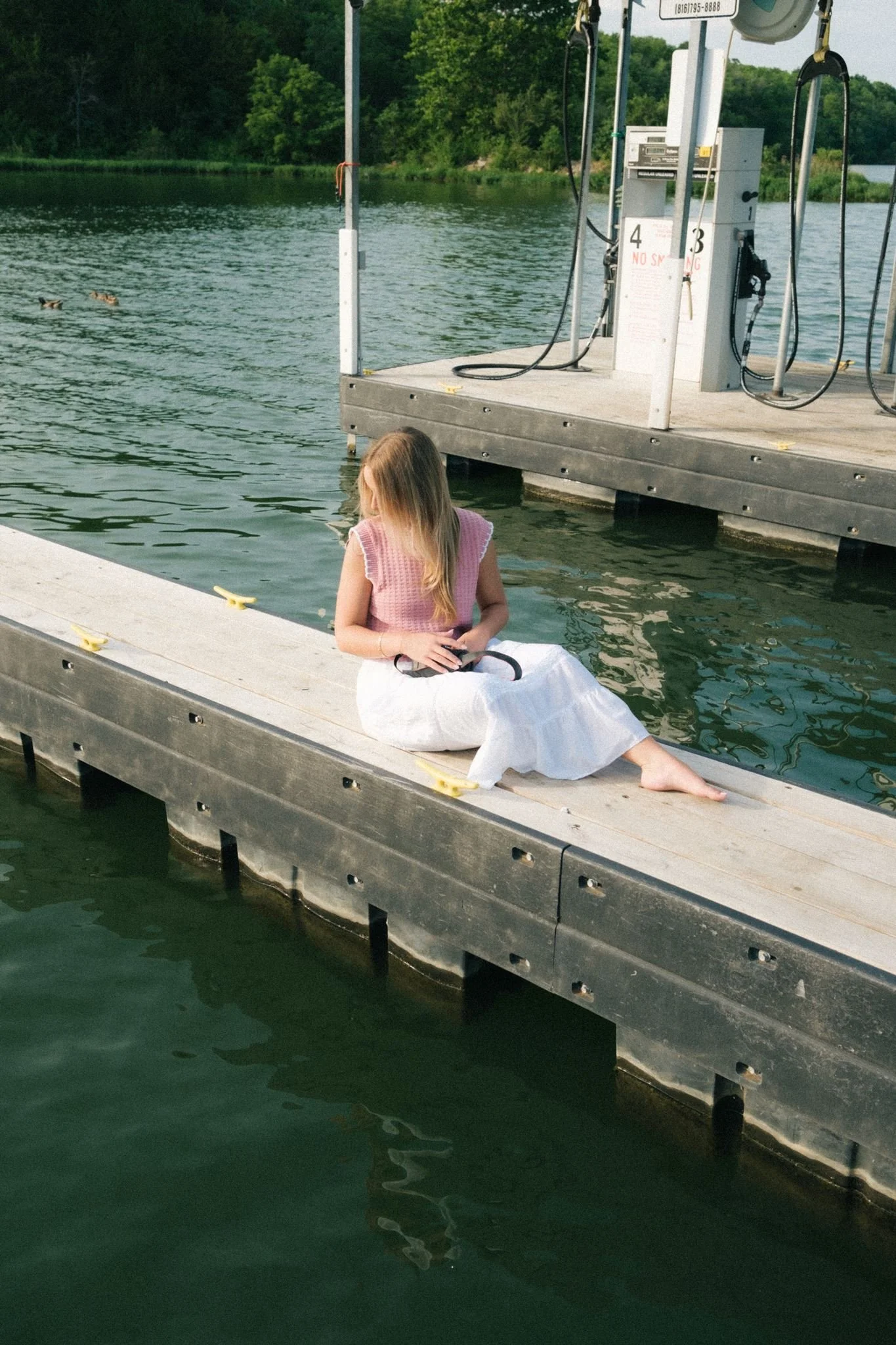  A woman sitting by the water for ideas for a brand photoshoot guide.  