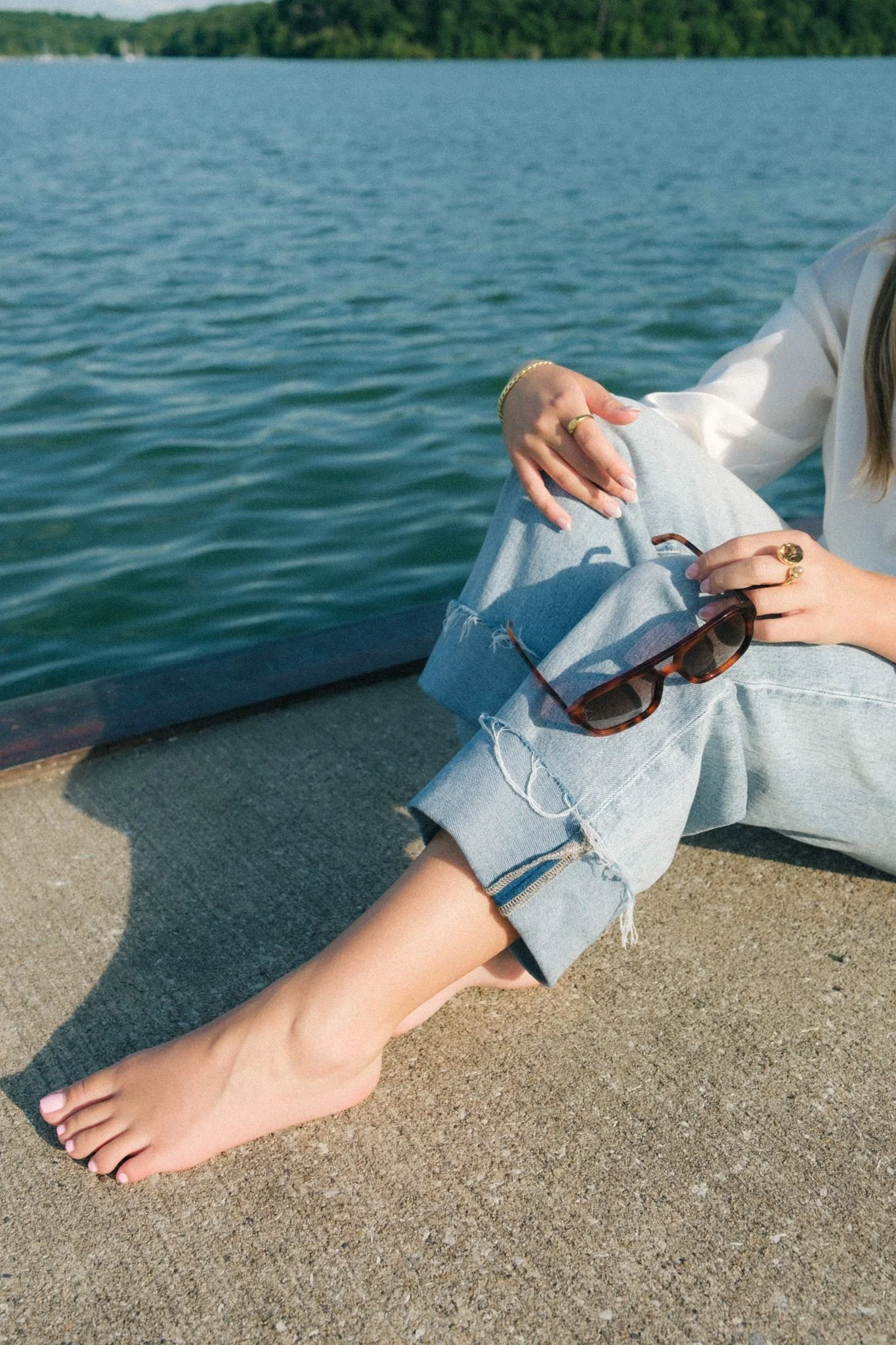  A woman holding sunglasses as a prop for a photoshoot guide. 