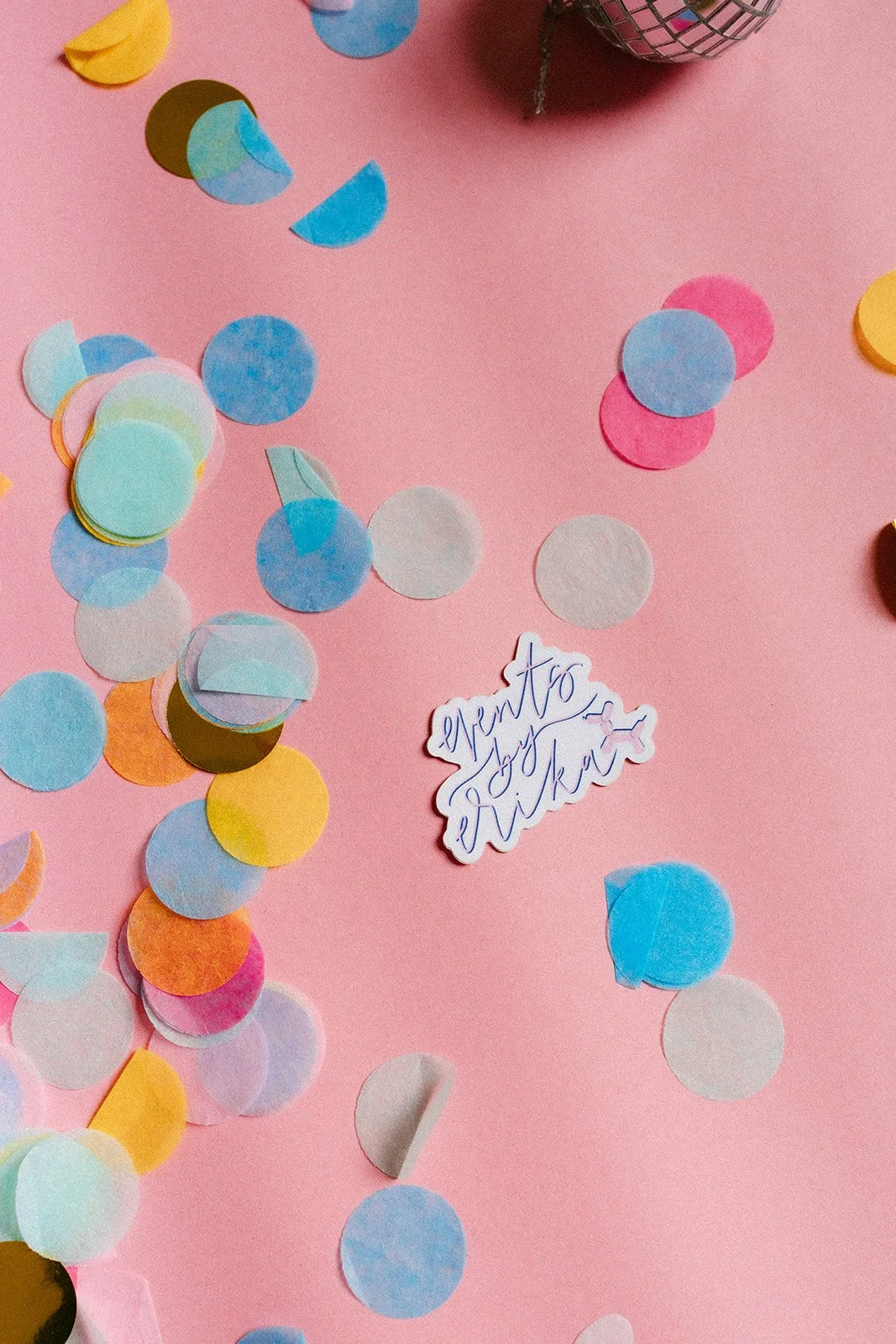  Confetti and a brand logo against a pink background for brand photos.  