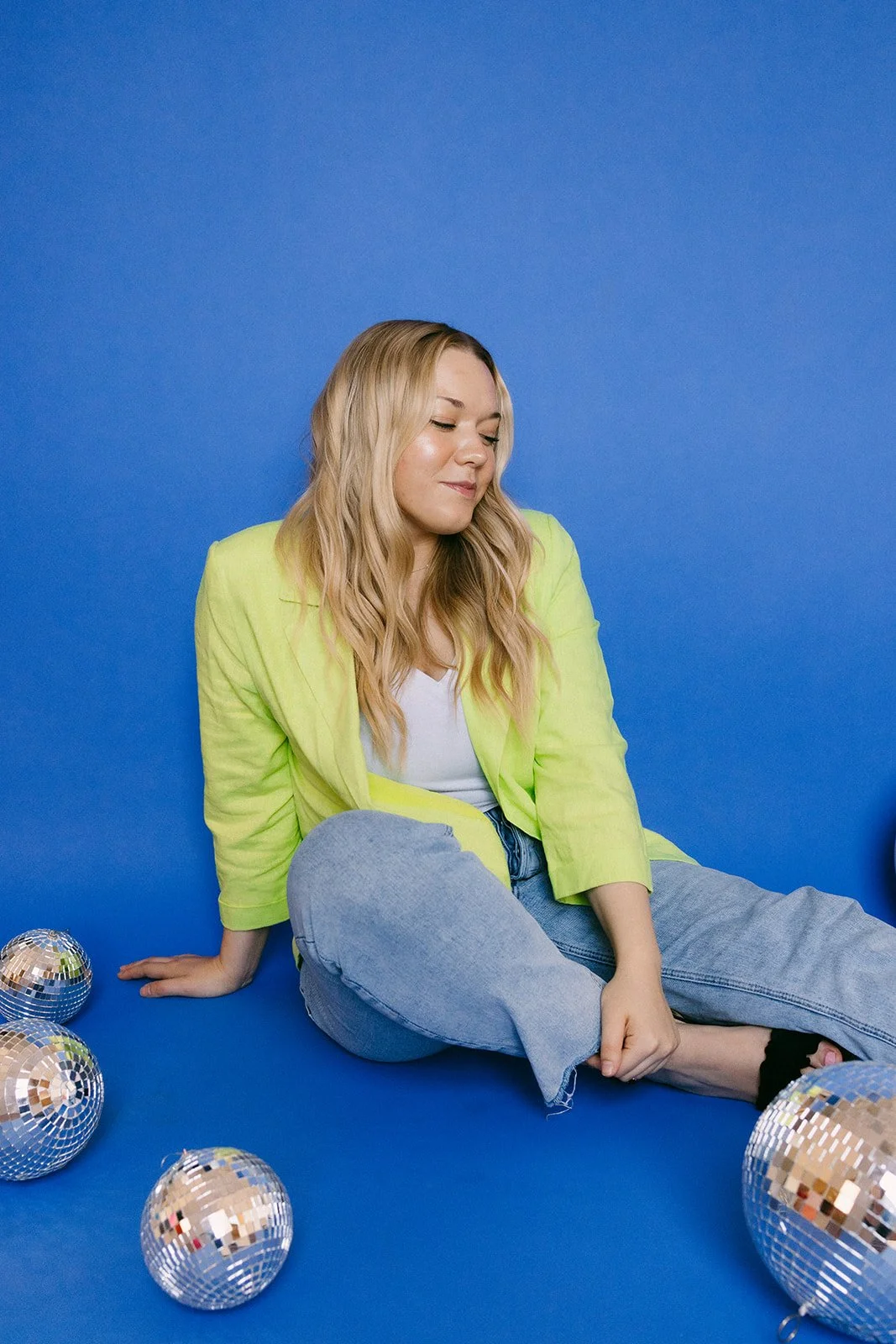  A woman sitting on the floor with disco balls for unique brand photos in Kansas City. 