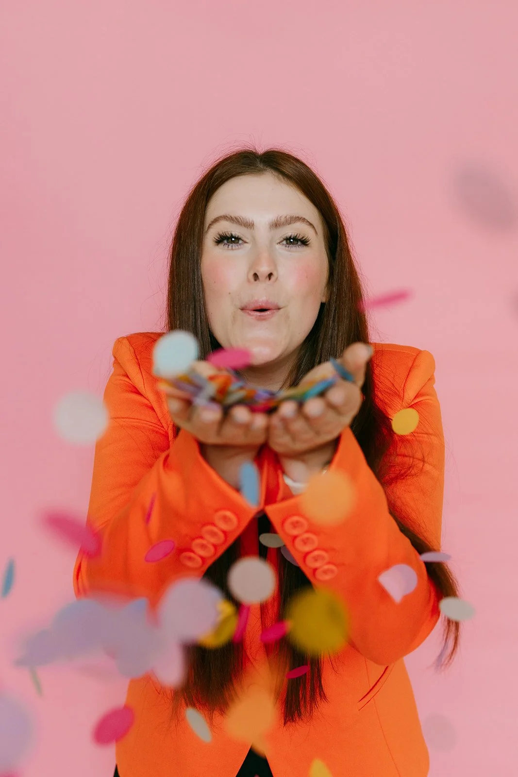  A woman blowing confetti in a Kansas City studio. 