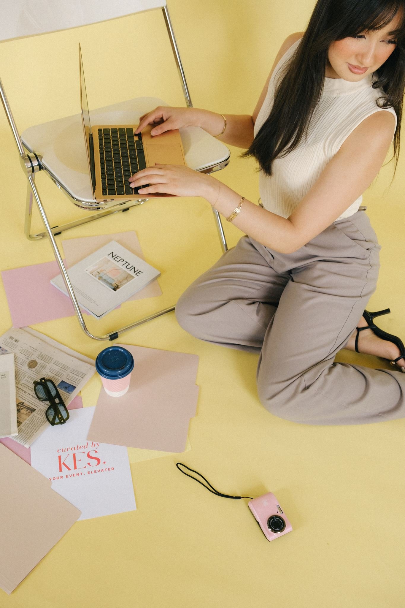A Kansas City business woman typing on a laptop surrounded by photoshoot prop ideas.