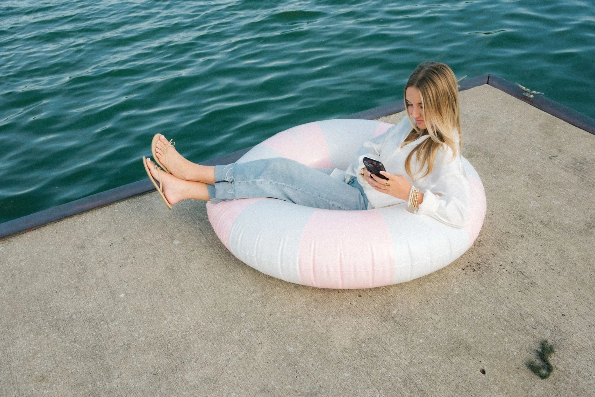 A business owner sitting in a pool float for unique brand photos in KC.