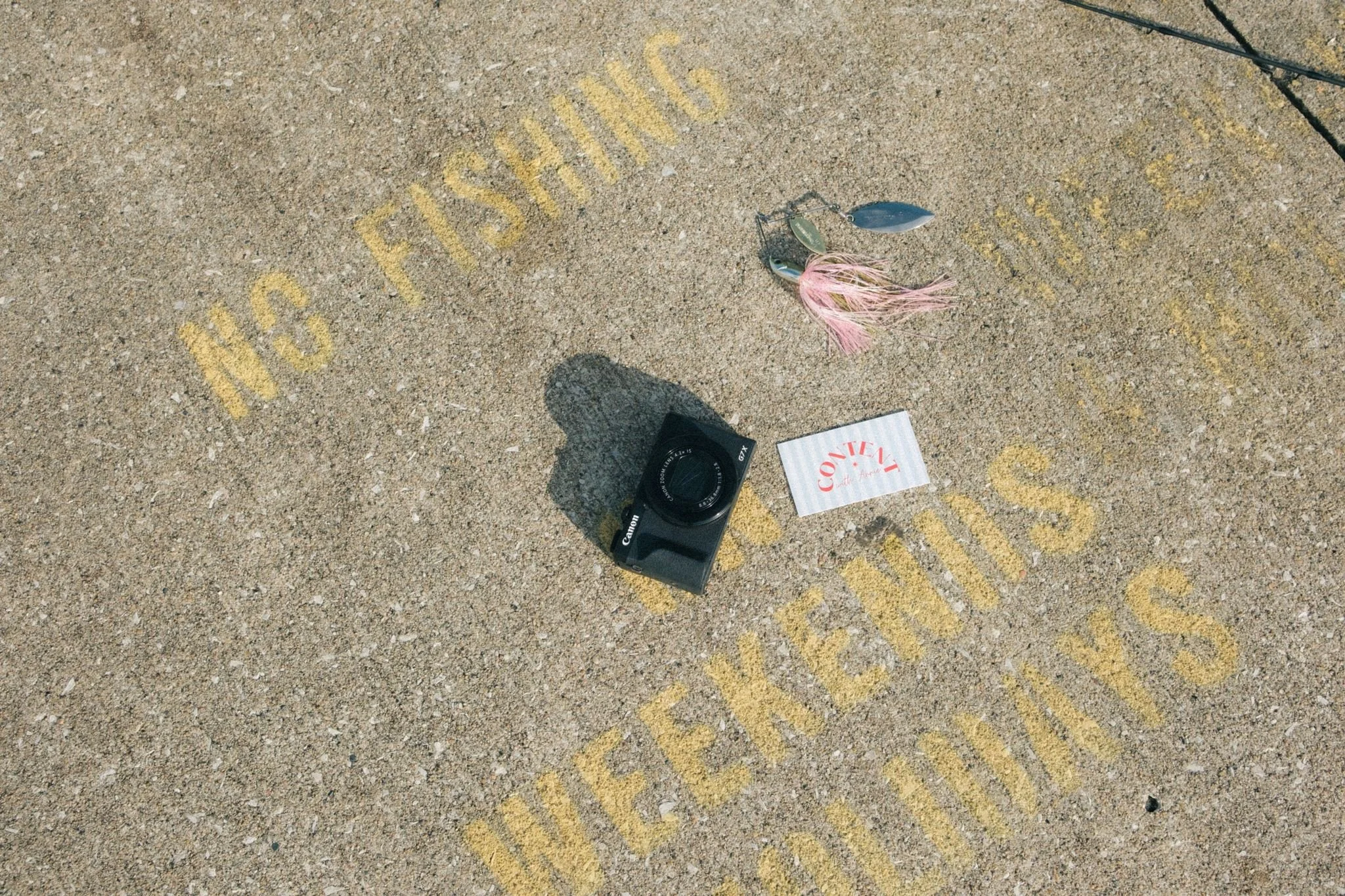 A camera and business card on the ground for prop ideas for the brand photoshoot guide.