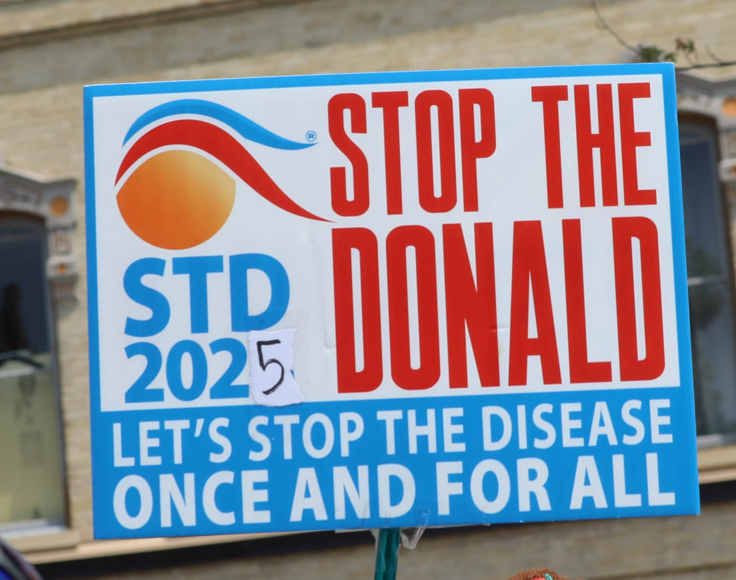 A political campaign sign featuring the logos of the Democratic and Republican parties. It includes a slogan urging to stop the disease once and for all and calls for action.