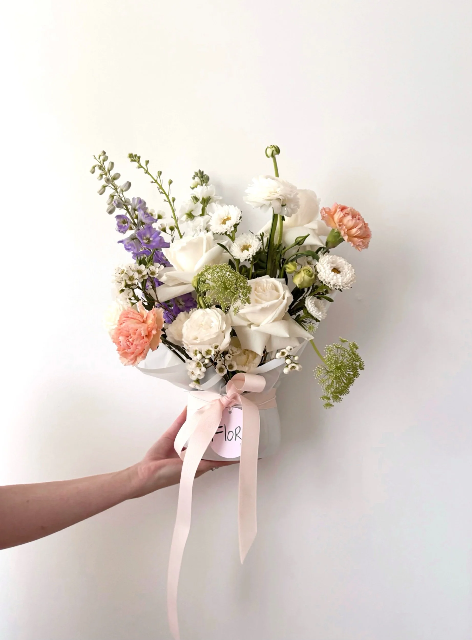 Elegant flower arrangement featuring mixed blooms in a white ceramic pot, by Flor Florals, Cairns Florist Cairns flowers