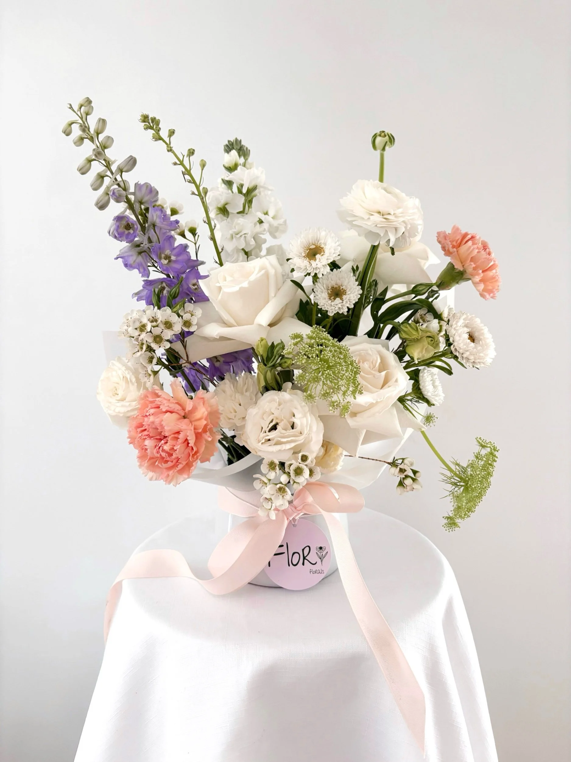 Elegant flower arrangement featuring mixed blooms in a white ceramic pot, by Flor Florals, Cairns Florist Cairns flowers