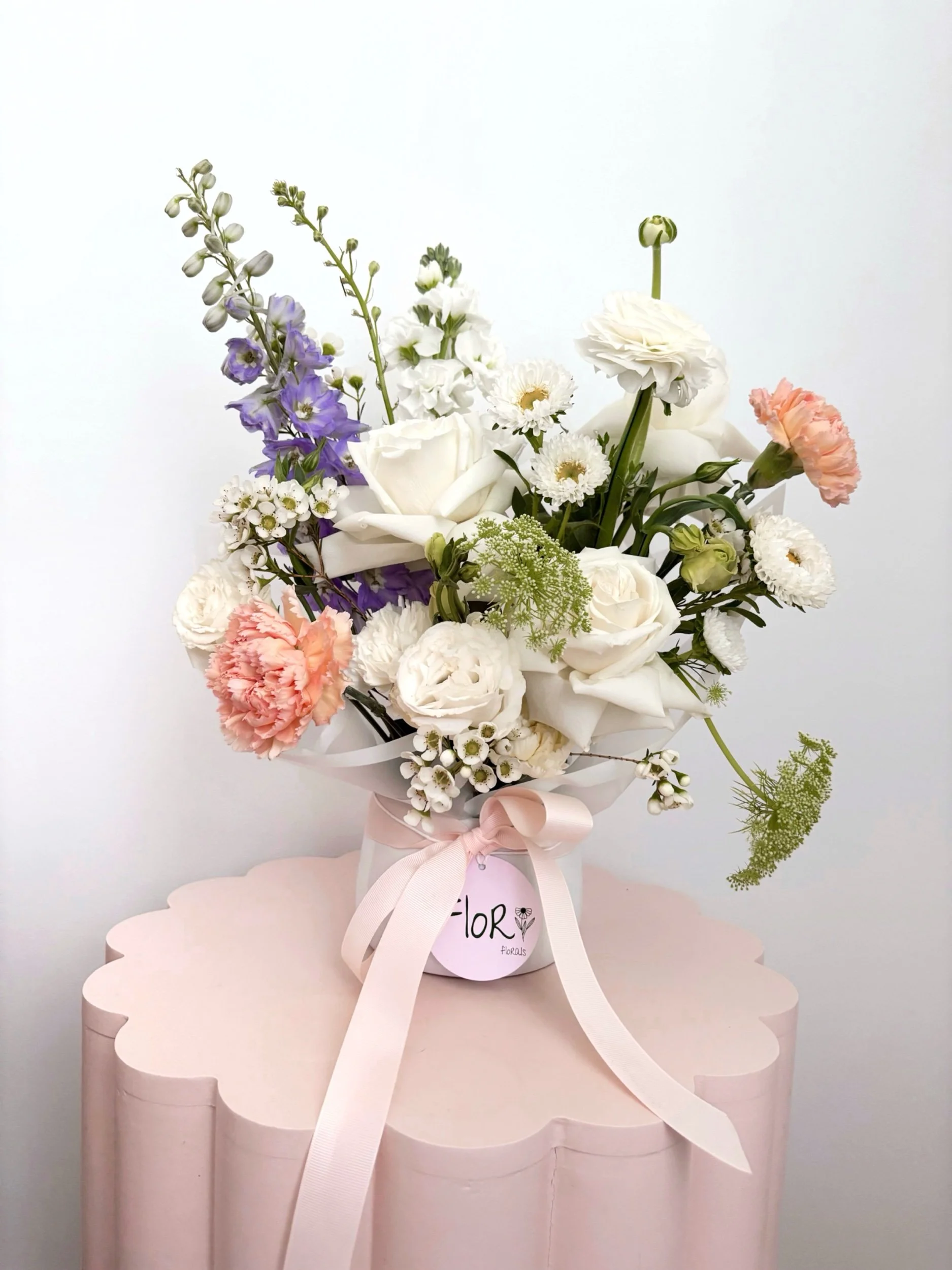 Elegant flower arrangement featuring mixed blooms in a white ceramic pot, by Flor Florals, Cairns Florist Cairns flowers