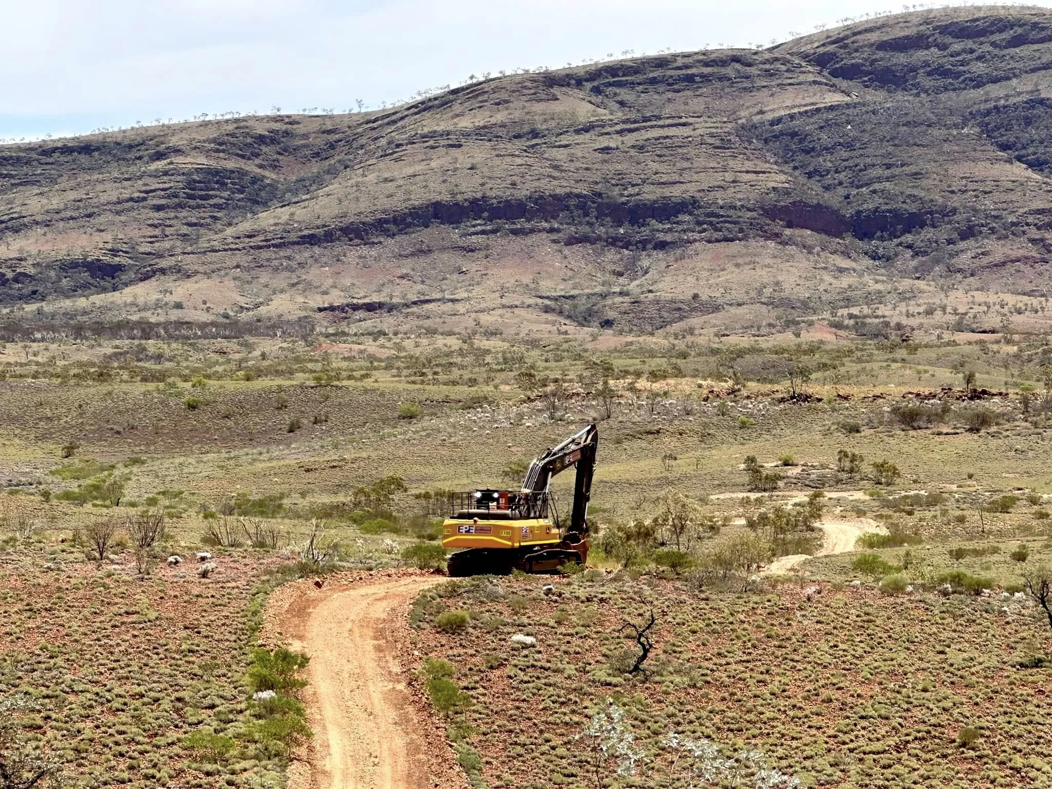 Excavator In Pilbara Remote Hill Landscape