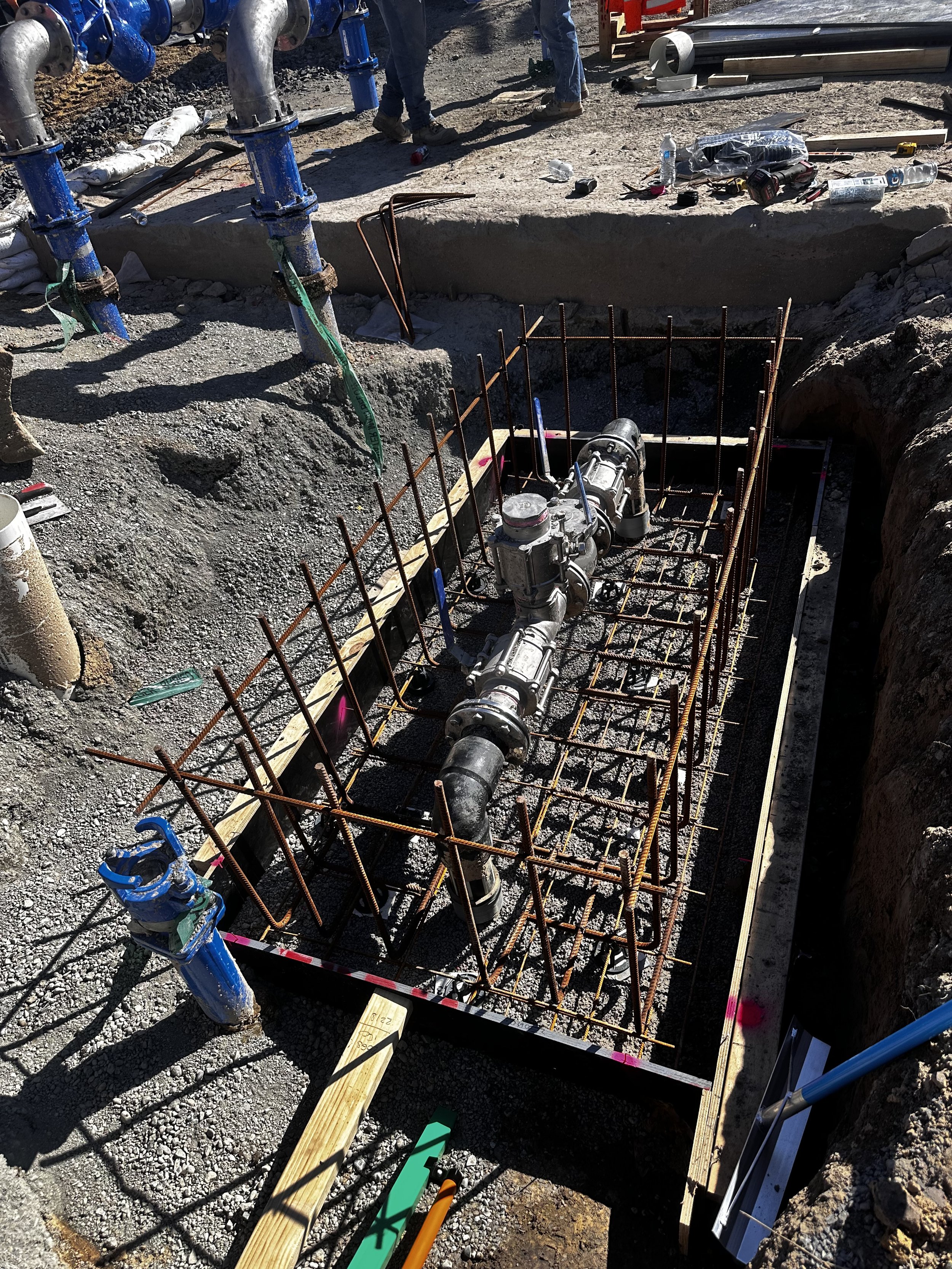 Construction site with exposed pipes and steel rebar framework