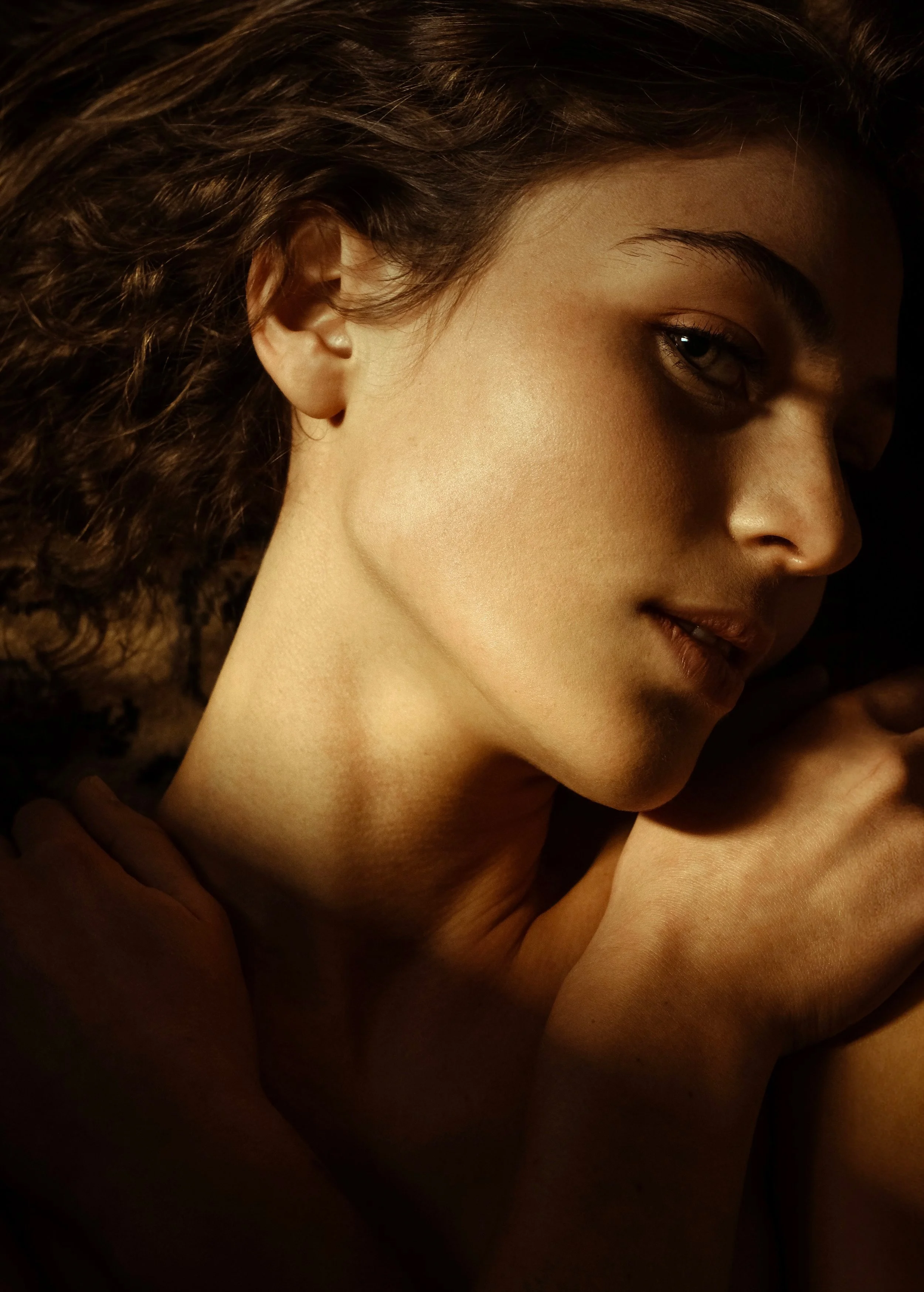 Primo piano di una persona sdraiata con luce soffusa sul viso