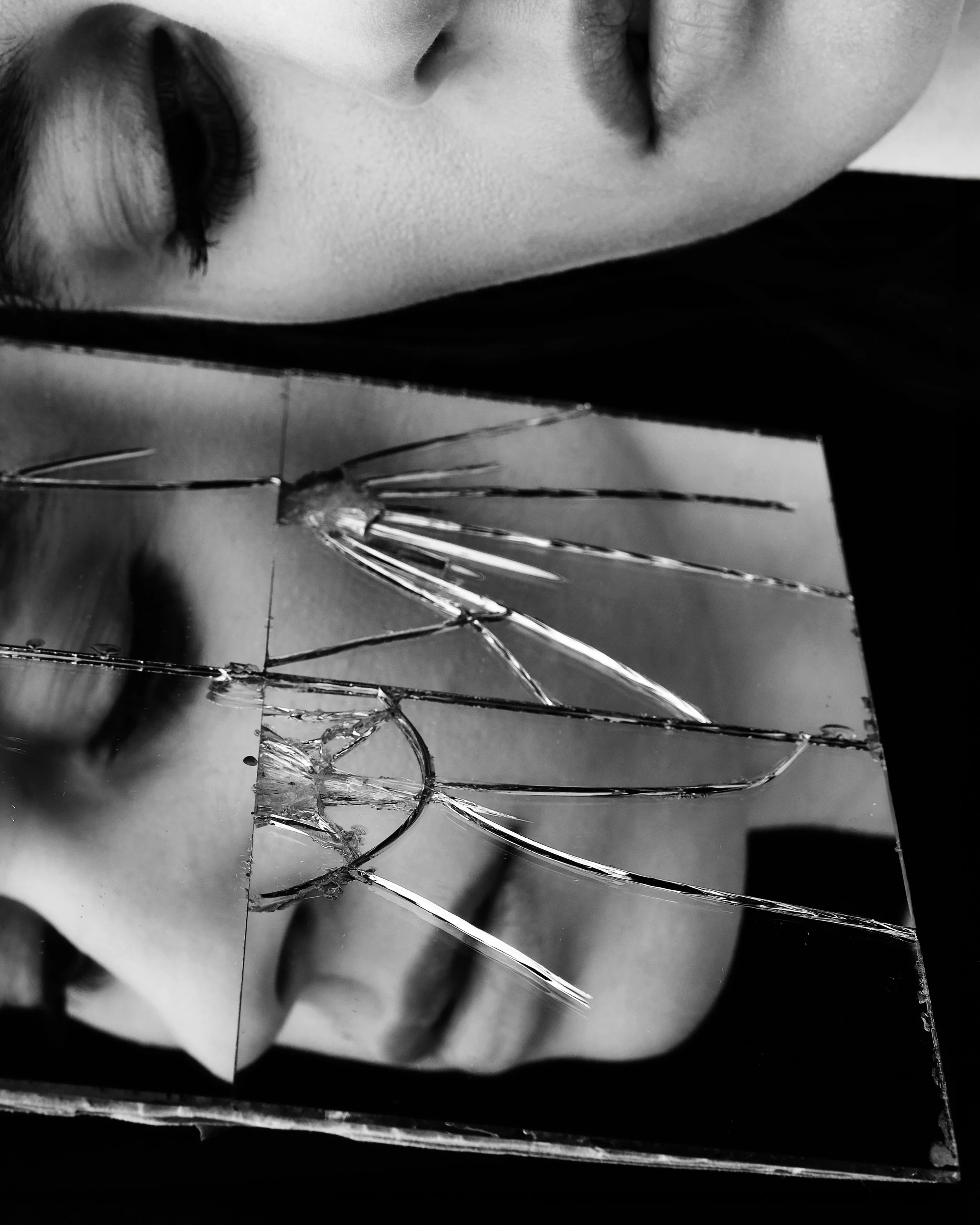 Primo piano di un volto riflesso in uno specchio rotto