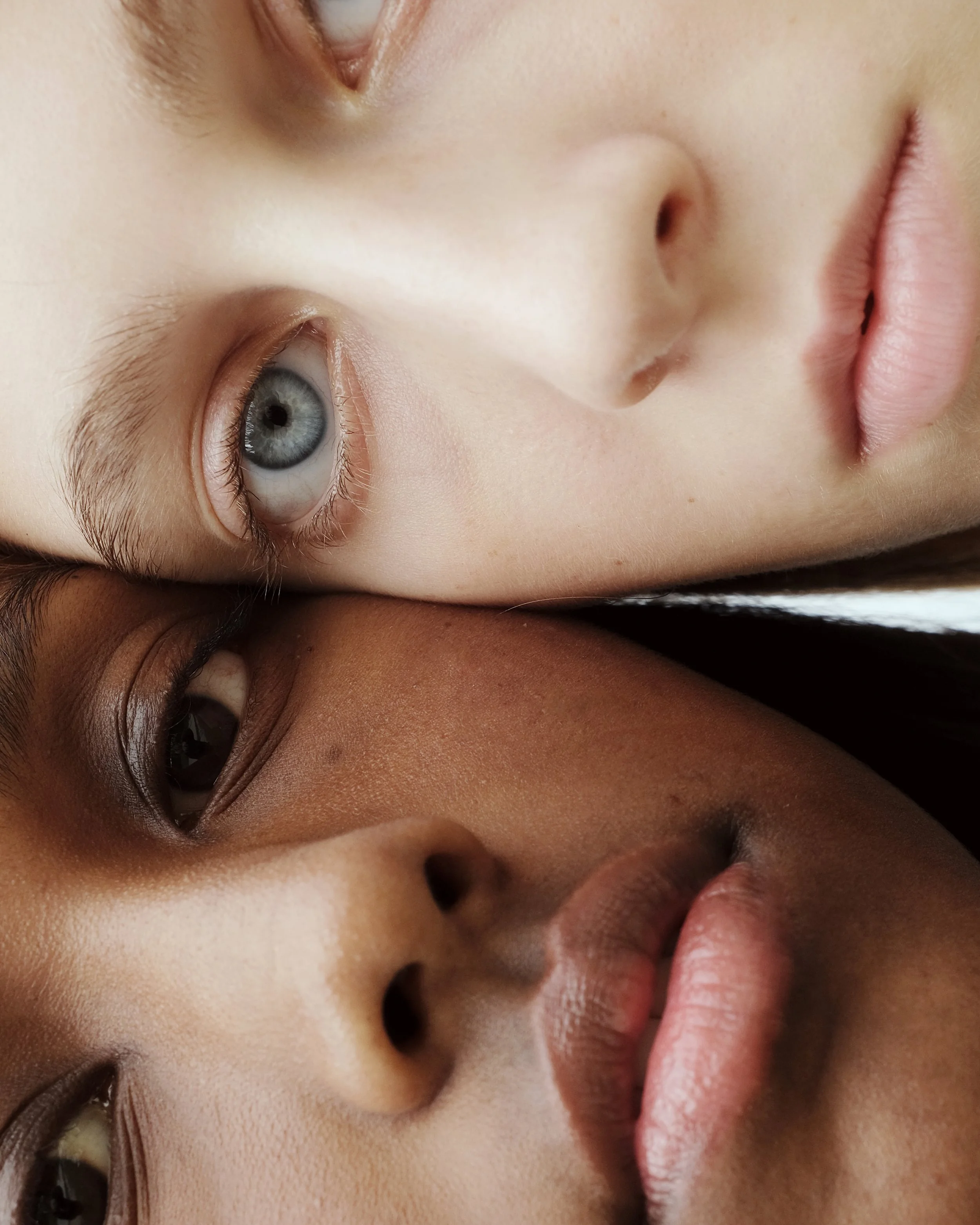 Due volti di donne con trucco naturale, vista ravvicinata, con toni caldi e freddi, uno con pelle chiara e occhi azzurri, l'altra con pelle più scura e occhi castani, entrambi con espressione neutra.