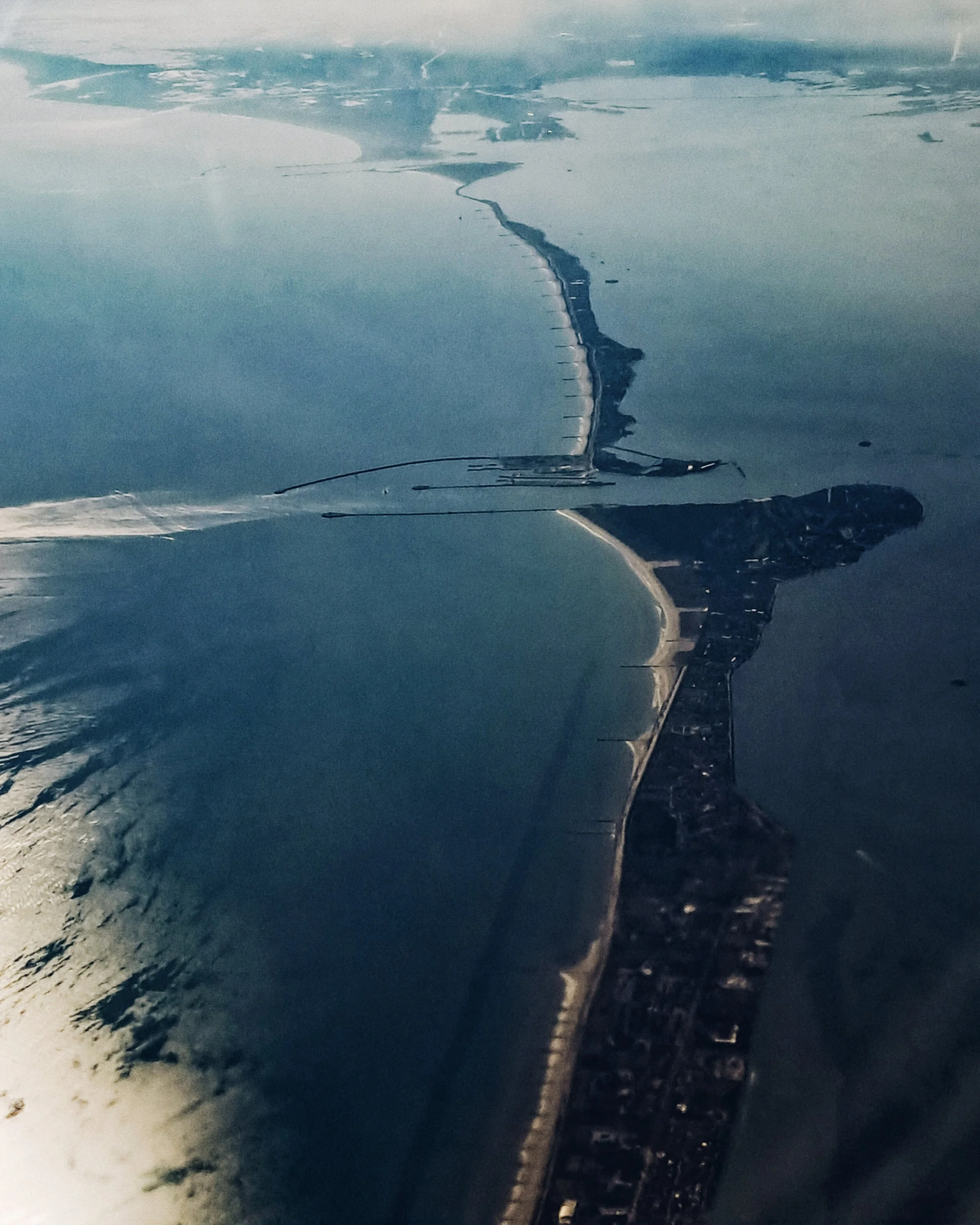 Veduta aerea di una diga e una città lungo la costa