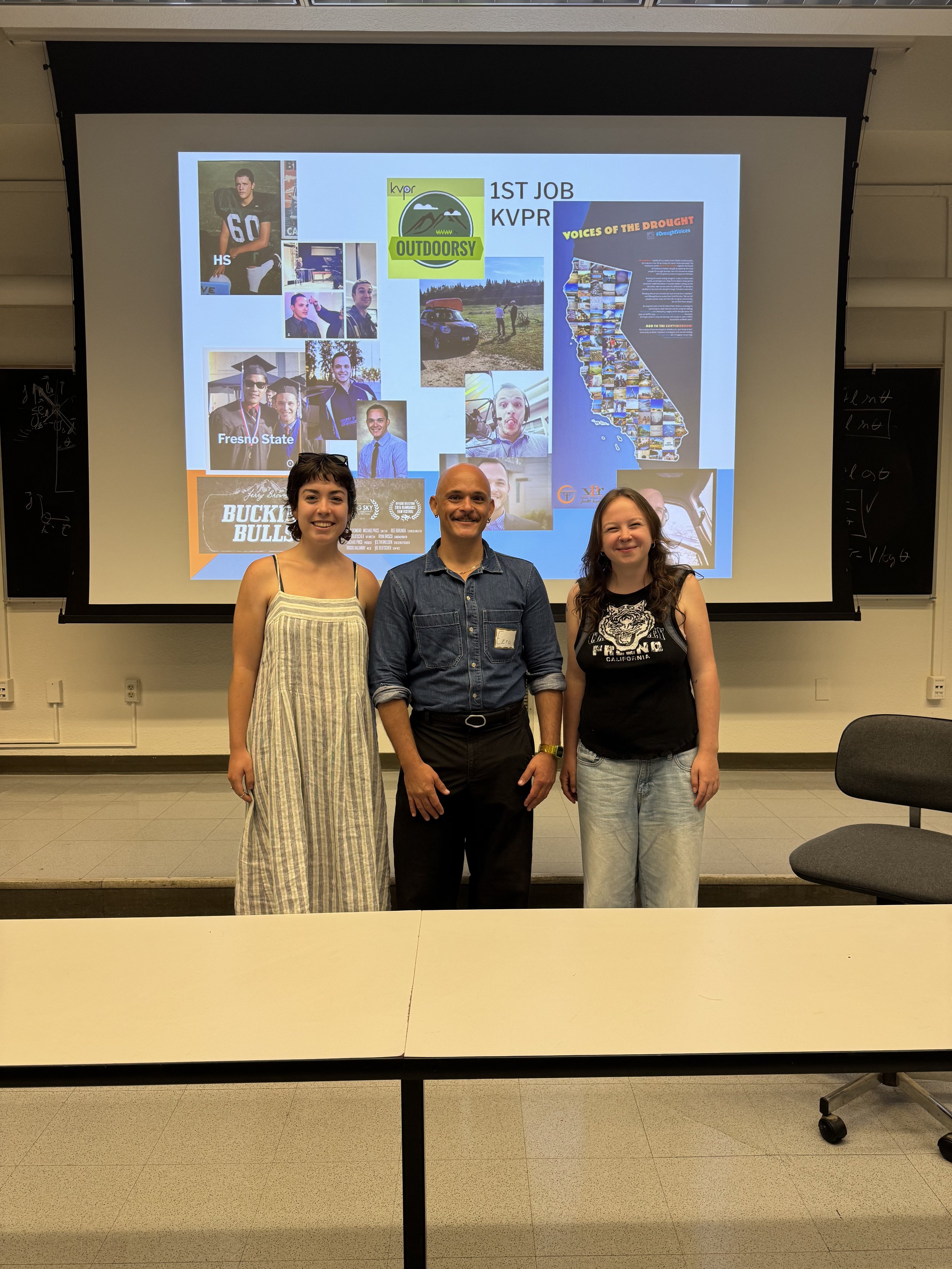 Three people standing in front of a classroom presentation screen. The screen displays a collage of photos, logos, and text including 'HS', 'Fresno State', and images of outdoor activities. The classroom has a black chalkboard and a beige wall.