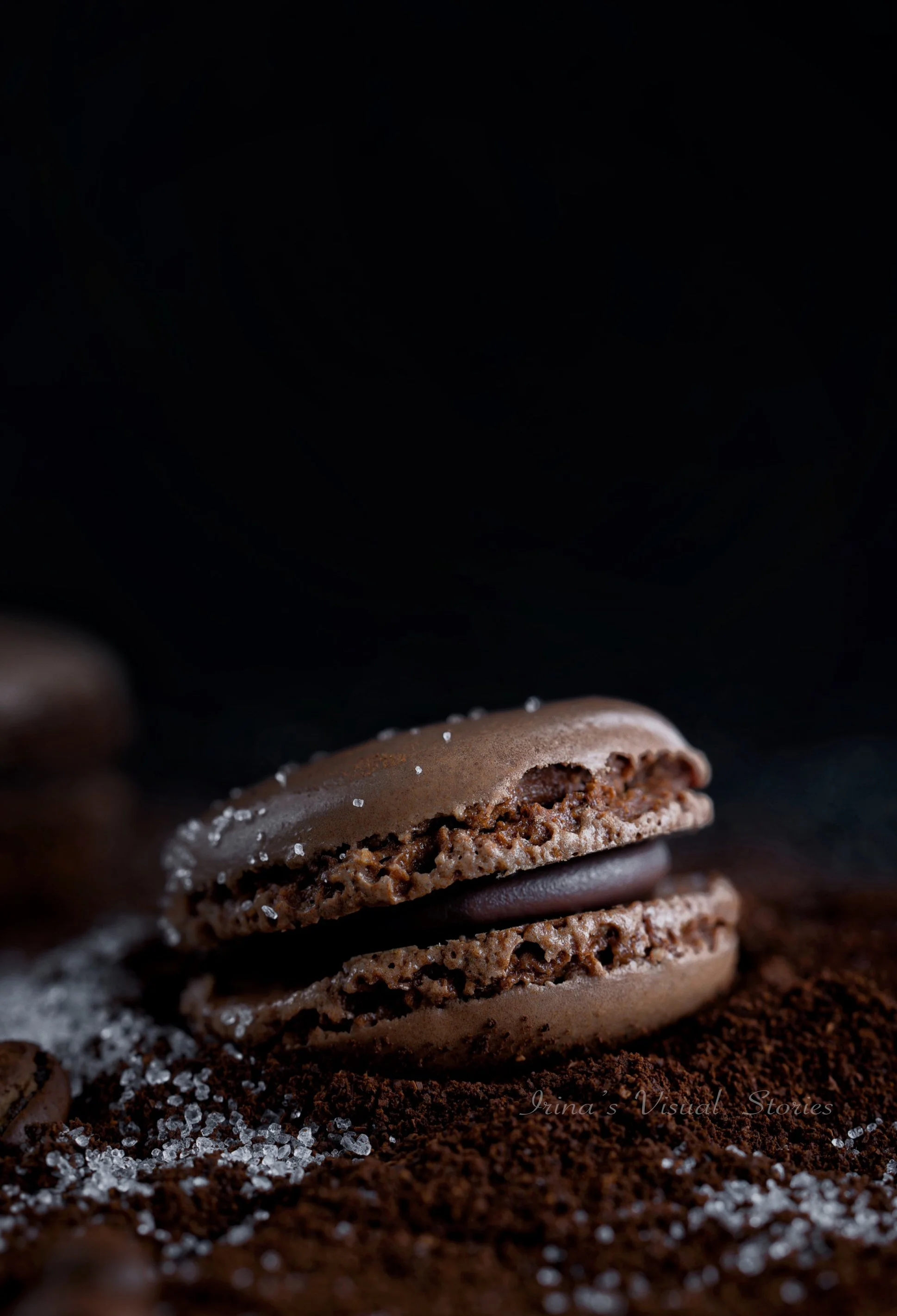 Die „Dark and Moody“-Fotografie verleiht Lebensmitteln eine unvergleichliche Tiefe und Eleganz. Bei diesem Shooting eines Schokoladen-Macarons lag der Fokus auf dem Spiel mit Texturen. Der Kontrast zwischen der glatten Oberfläche des Gebäcks, dem sta