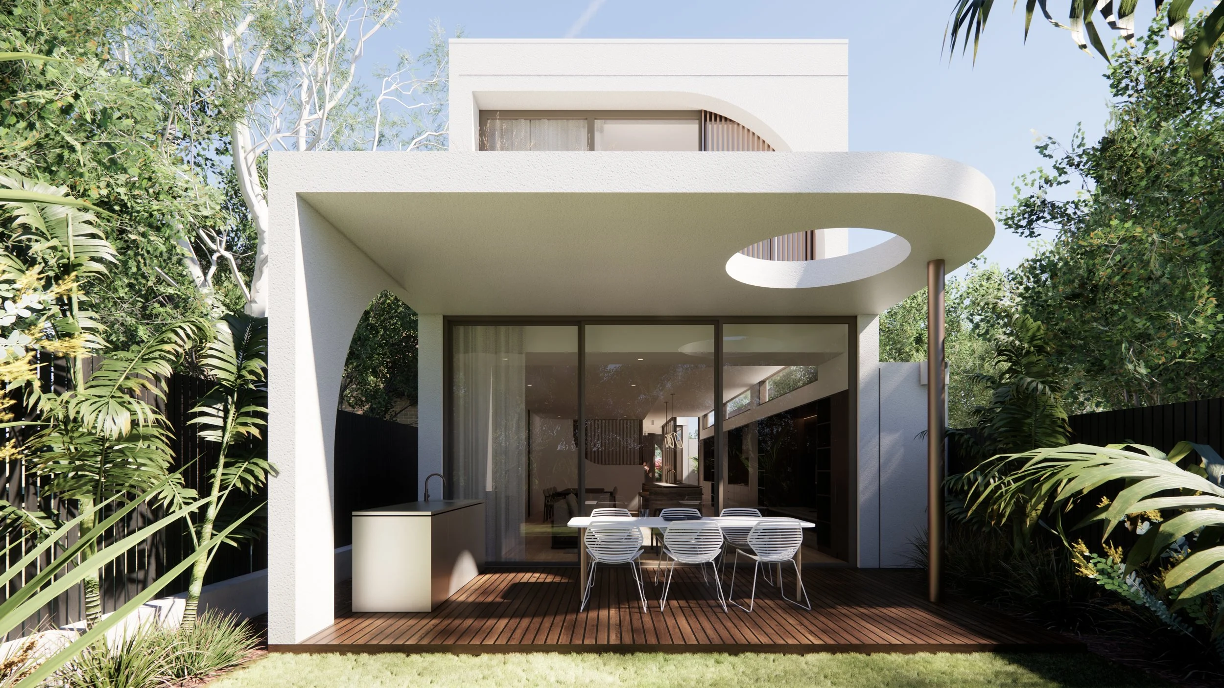 Modern two-story white house with open outdoor patio, glass sliding doors, wooden deck, and surrounded by lush greenery and trees.