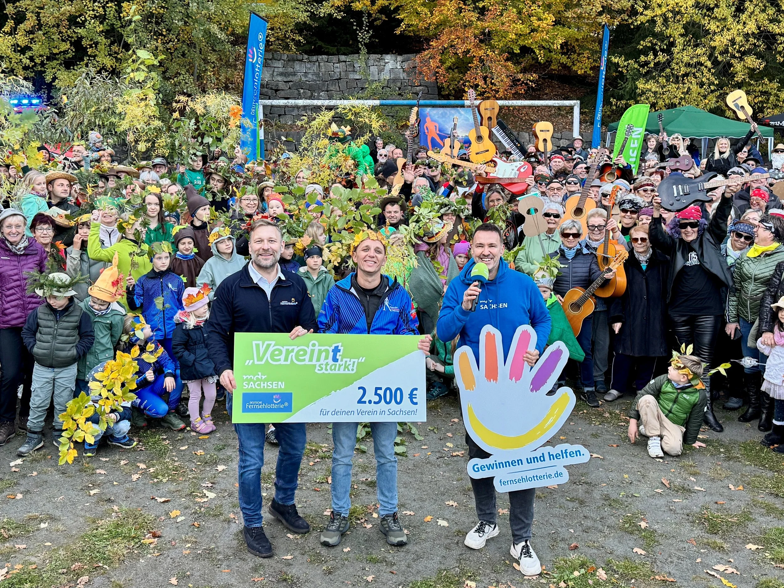 Siegerfoto: Vereinsmitglieder und Unterstützer des Vereins mit dem MDR Sachsen mit einem Geld check von 2500€