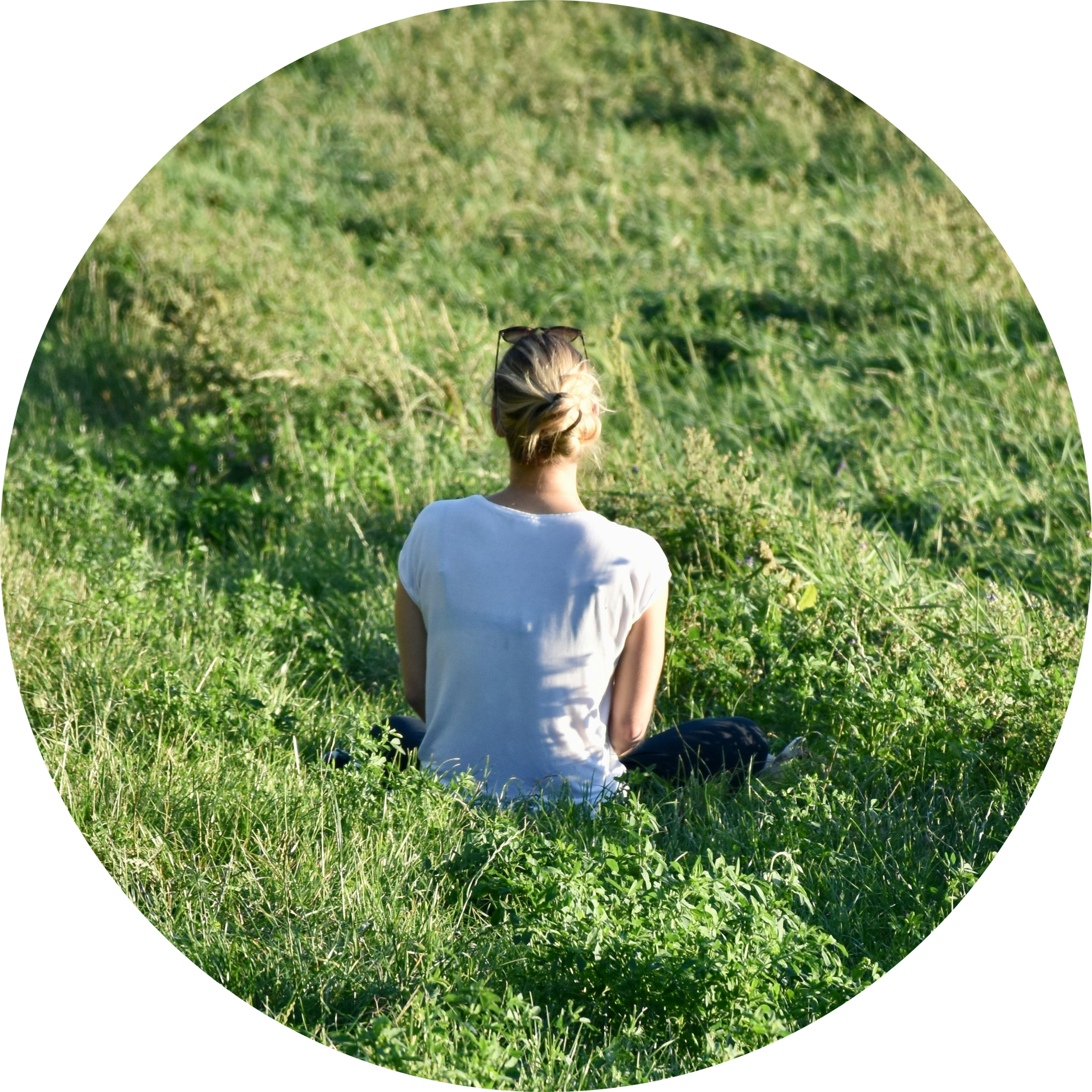 Lara Keegan, Fremantle counsellor, sitting quietly in a field of grass.